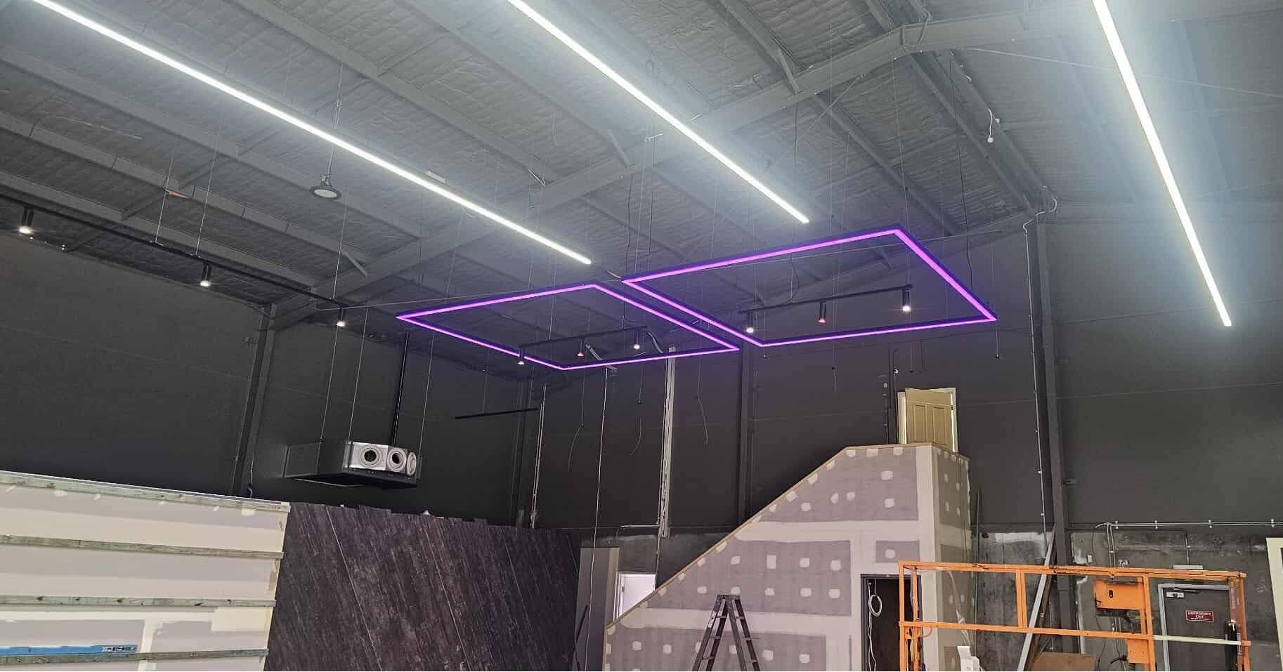 Indoor Warehouse with A Purple-Lit Ceiling Frame and Dark Walls — Macleay Energy Solutions In Kempsey, NSW