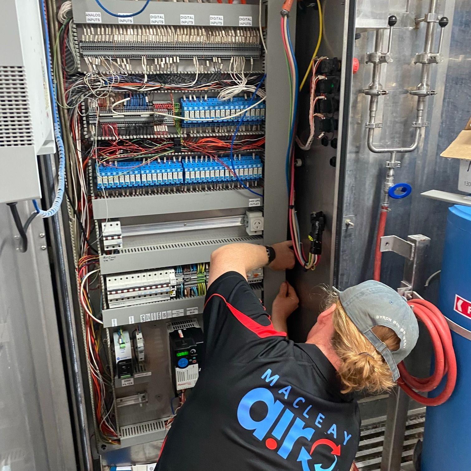 Technician Wiring an Open Electrical Control Panel in An Industrial Setting — Macleay Energy Solutions In Kempsey, NSW