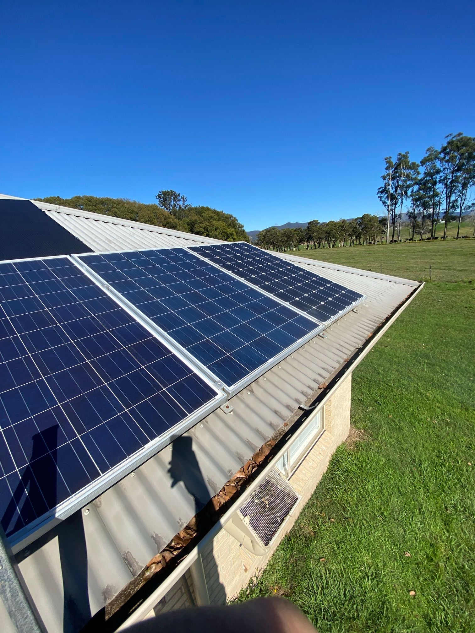 Solar Panels on A Rooftop Under a Clear Blue Sky — Macleay Energy Solutions In Kempsey, NSW