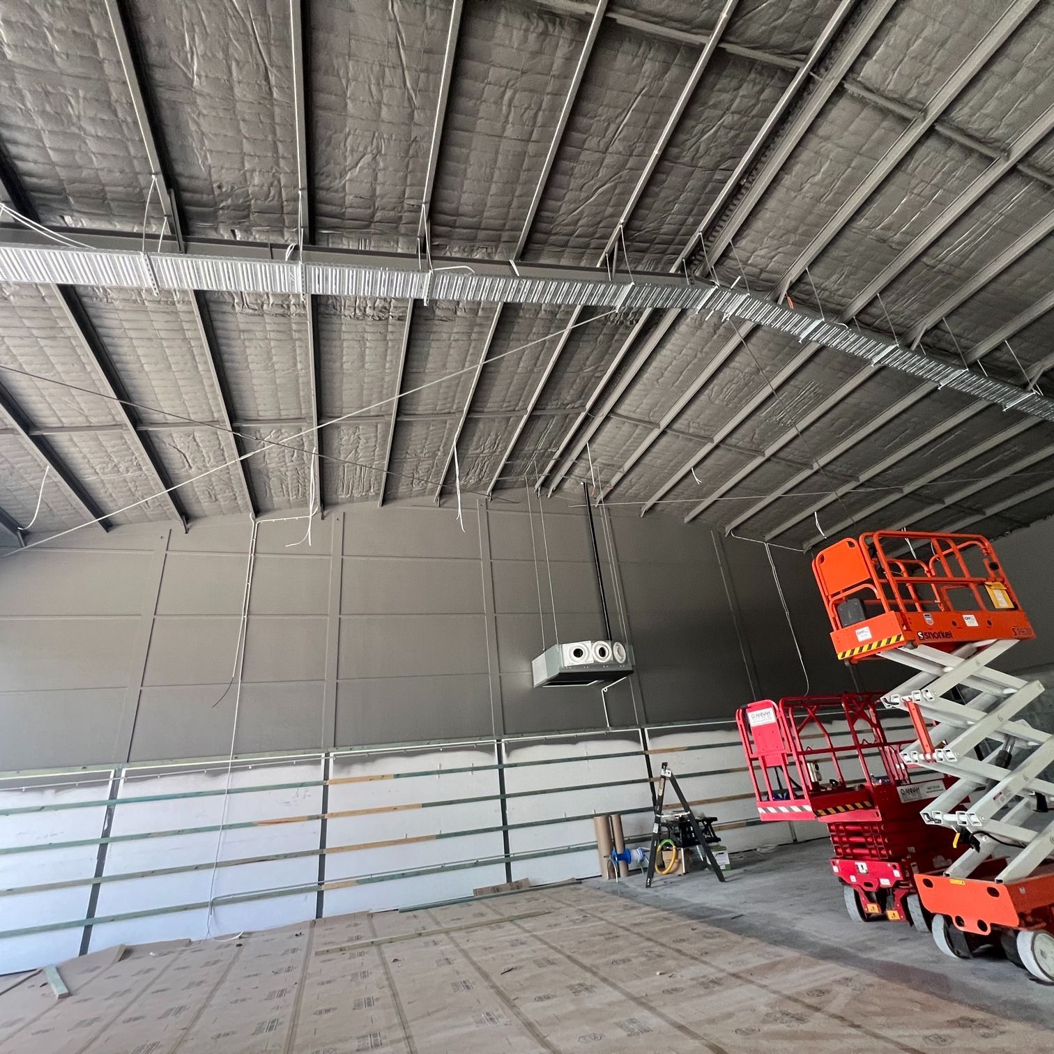 Industrial Warehouse Interior with High Metal Ceiling and Scissor Lifts — Macleay Energy Solutions In Kempsey, NSW
