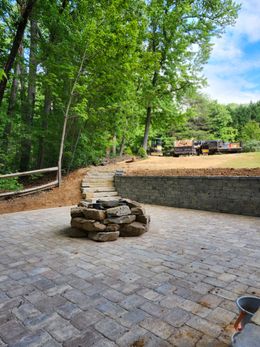 A fire pit is sitting on top of a brick patio.