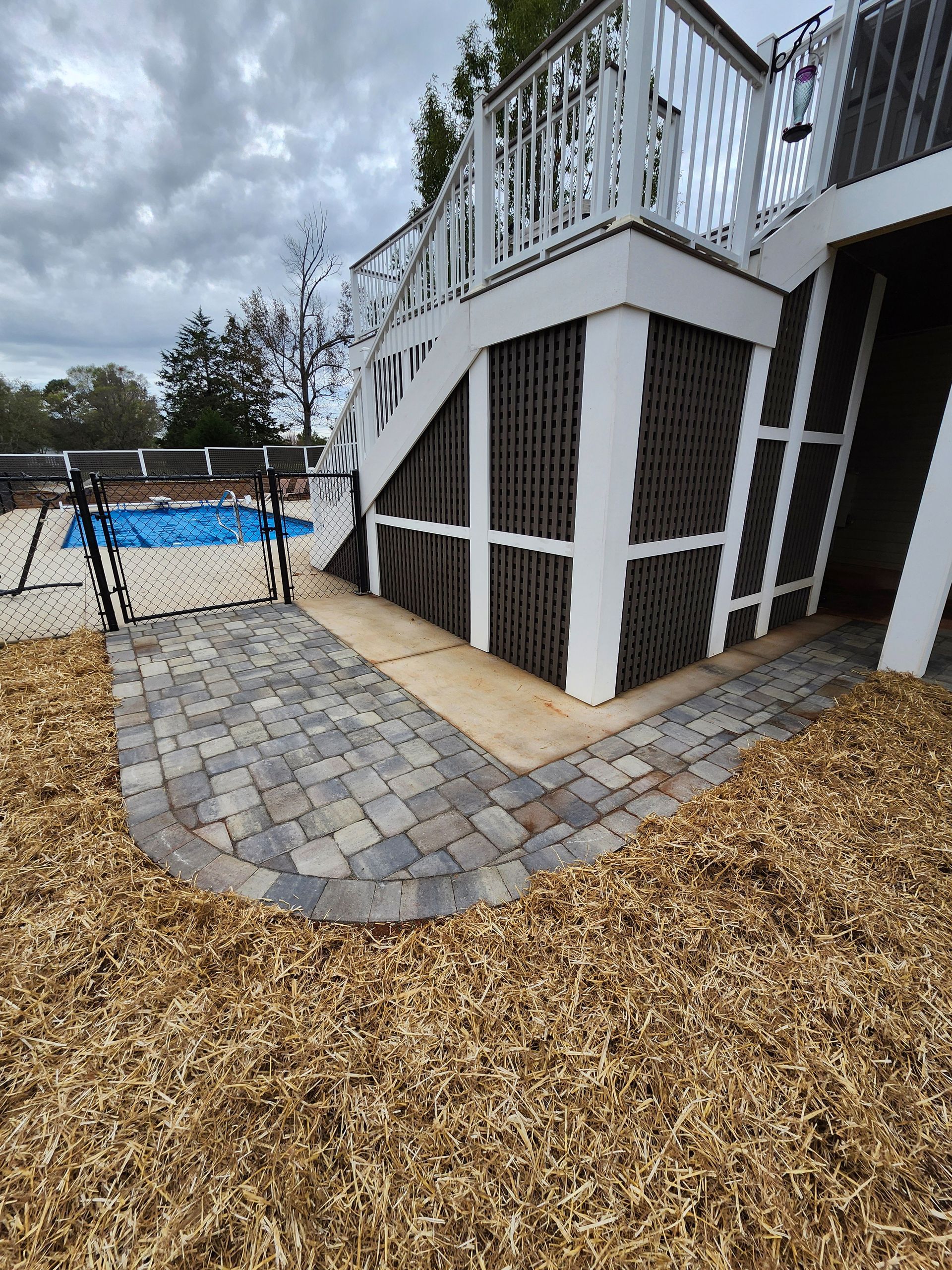 A patio with a staircase leading up to a swimming pool.