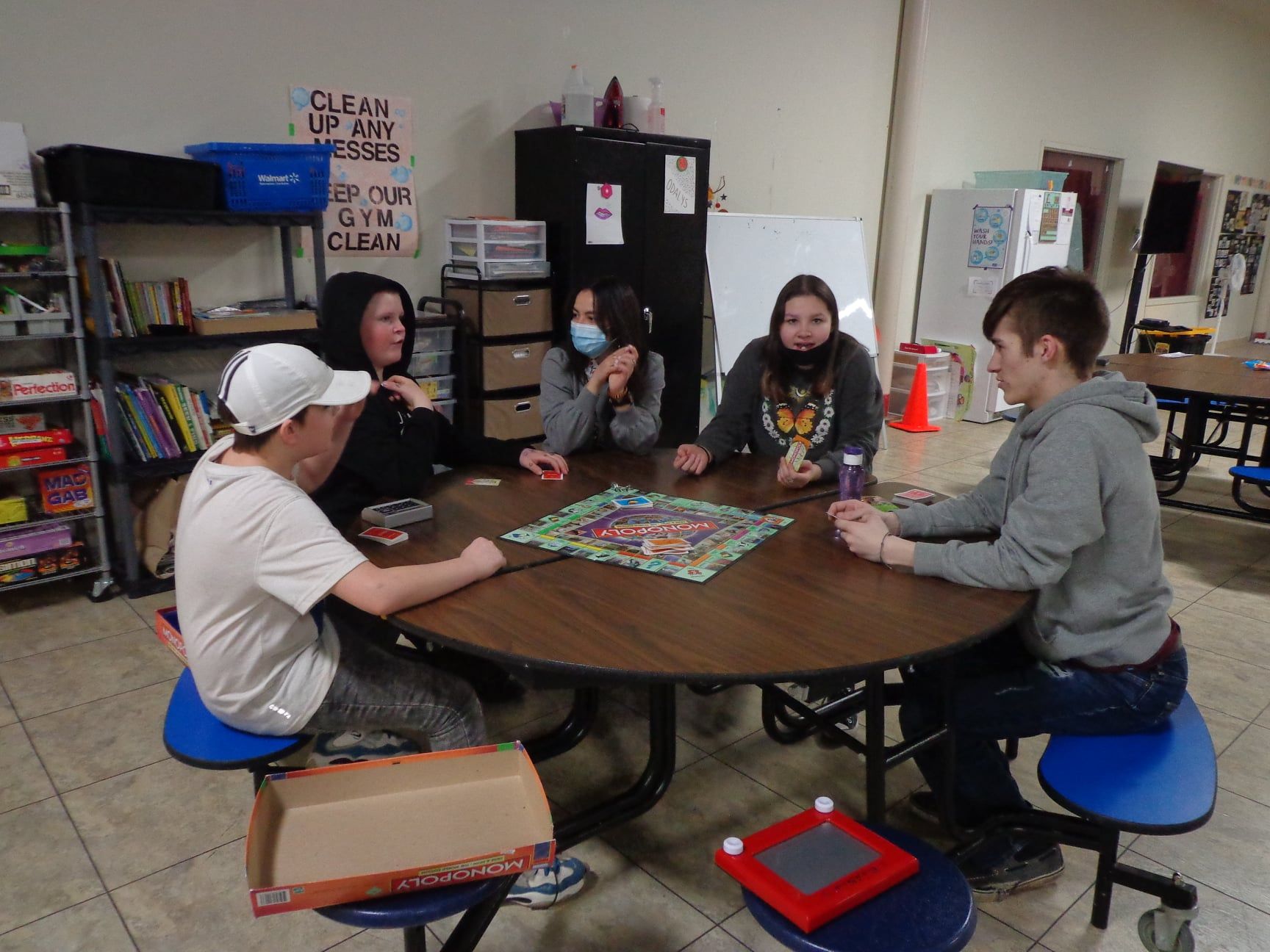 A group of people are sitting around a table playing a board game.