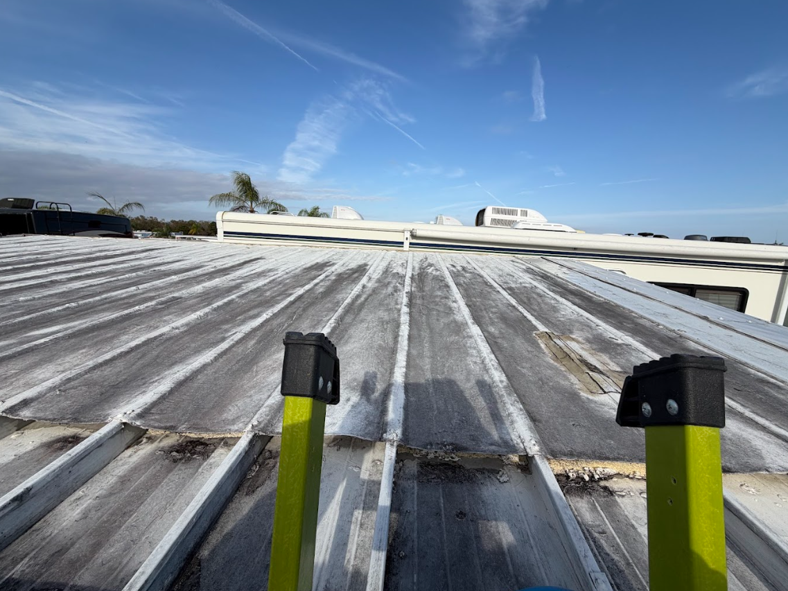 Rooftop with silver corrugated panels and two yellow poles under a blue sky