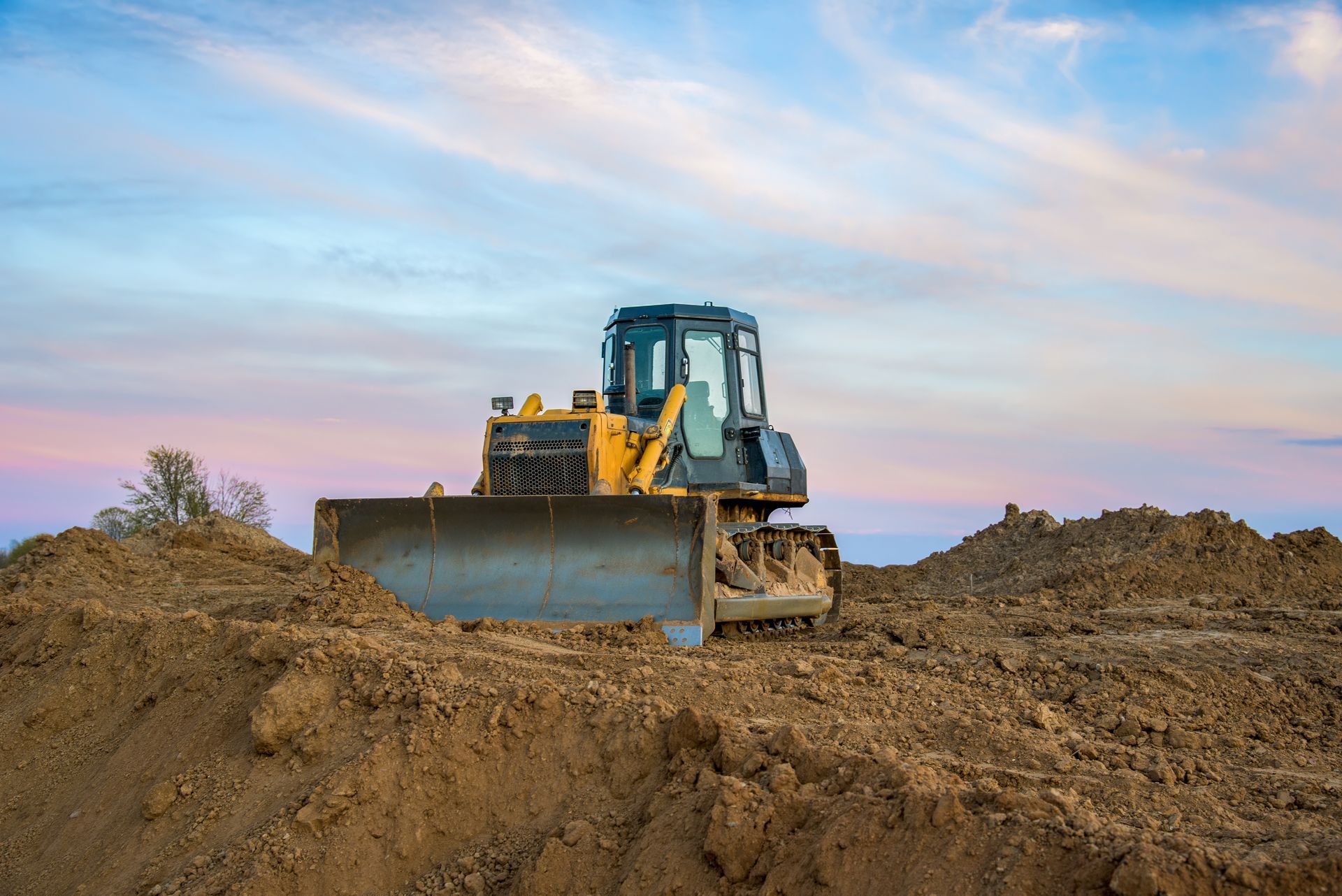 A Bulldozer is Moving Dirt on a Construction Site — Tomac Civil In Burleigh Heads, QLD