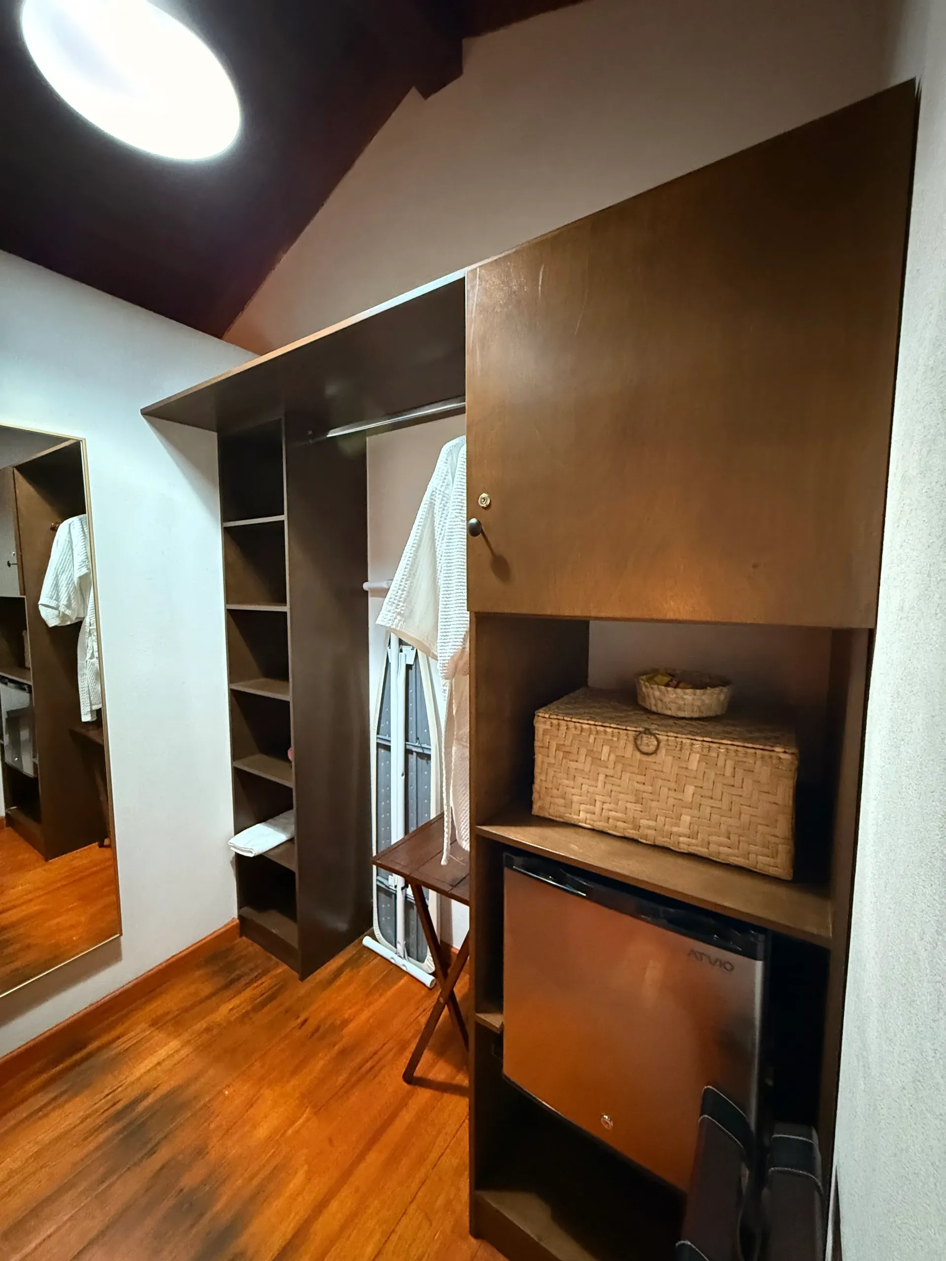Un vestidor con refrigerador y espejo.