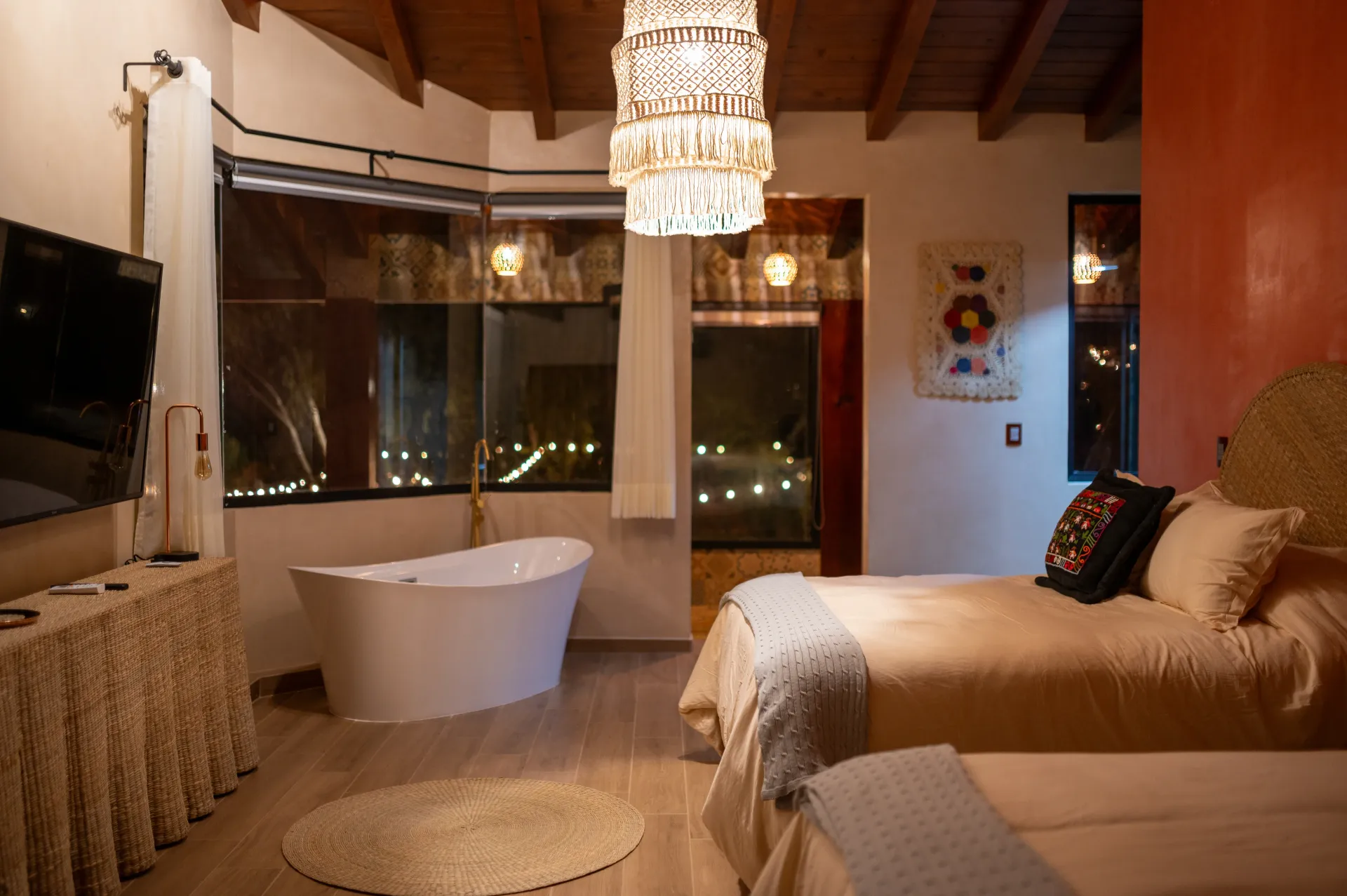 Un dormitorio con dos camas, una bañera y una televisión.