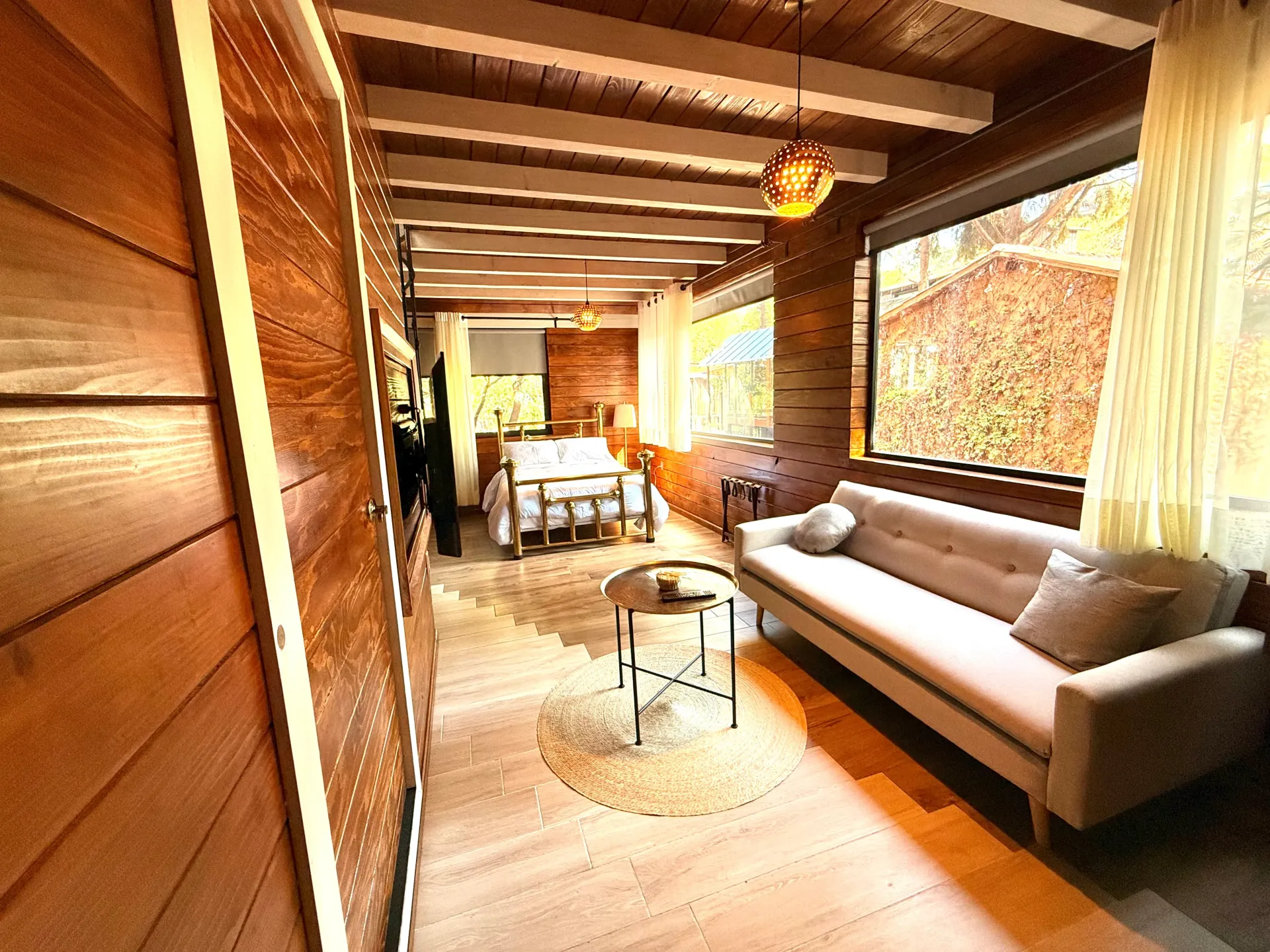 Una sala de estar con sofá, mesa y ventana.