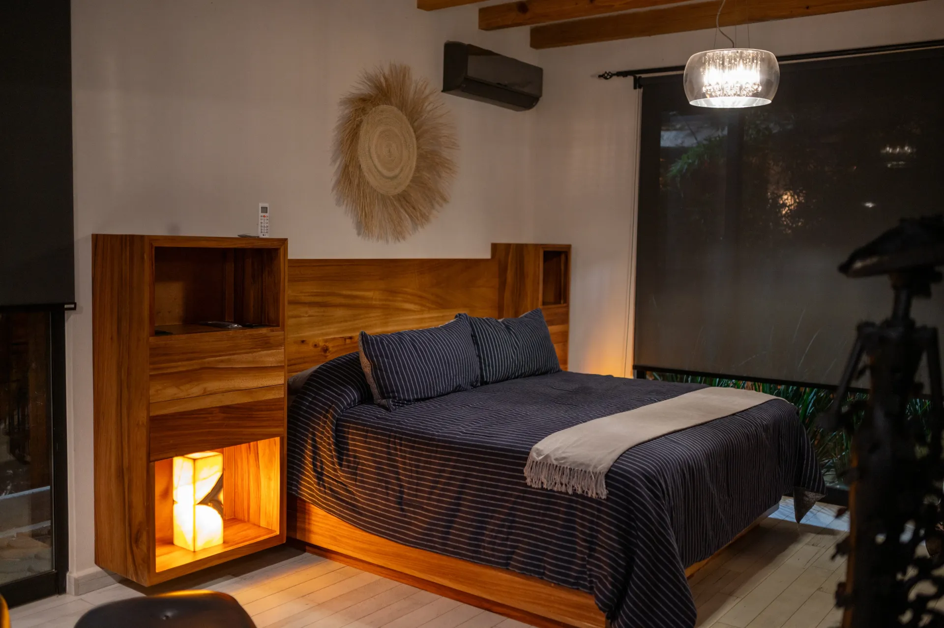 Un dormitorio con una cama, mesitas de noche y una ventana.