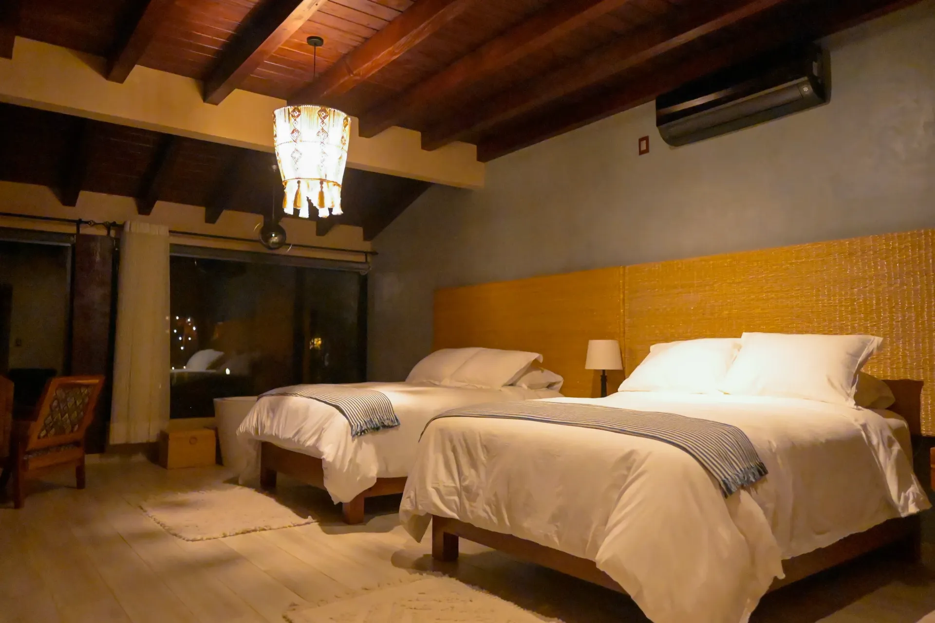Una habitación de hotel con dos camas y una lámpara de araña colgando del techo.