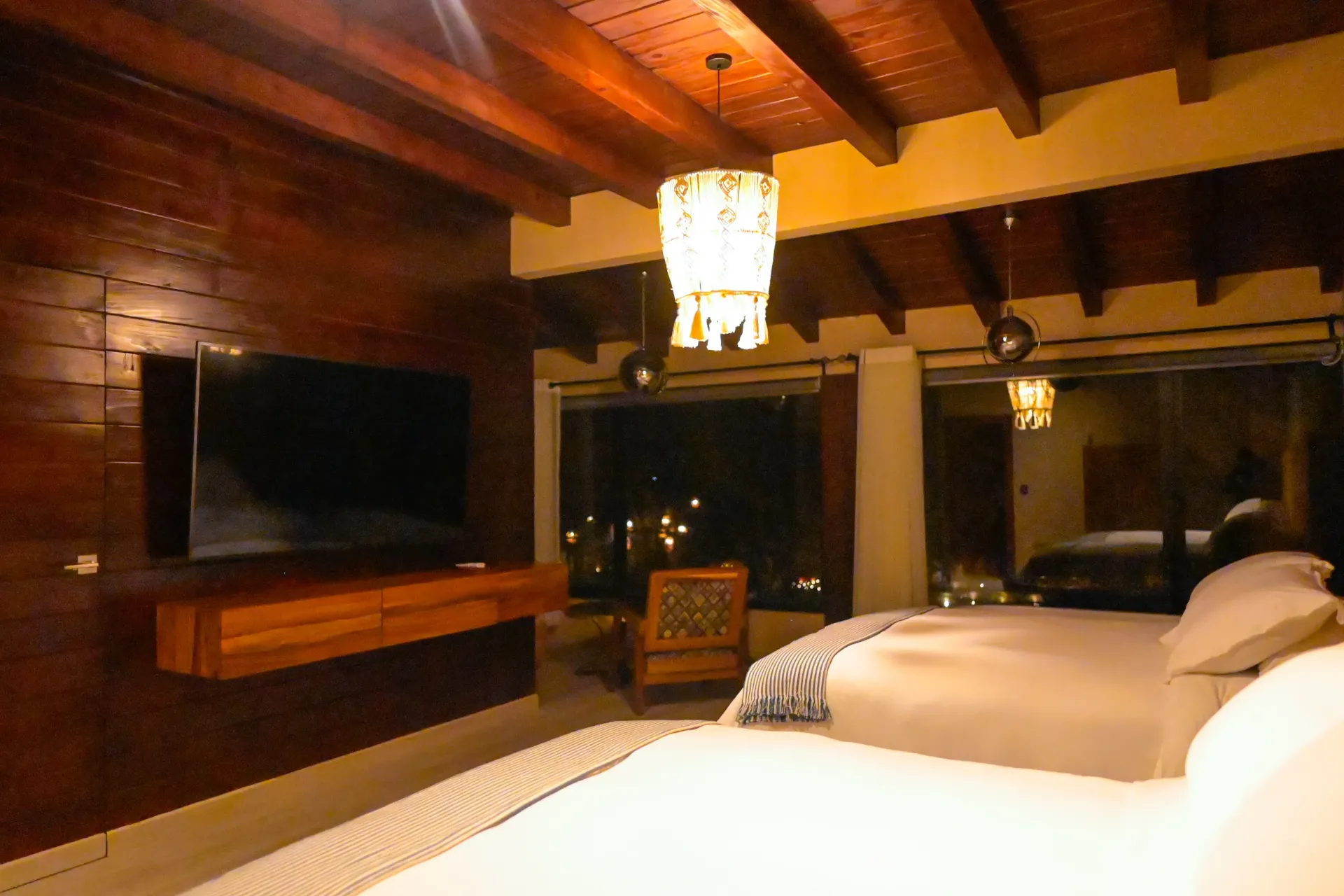 Una habitación de hotel con dos camas y un televisor de pantalla plana.