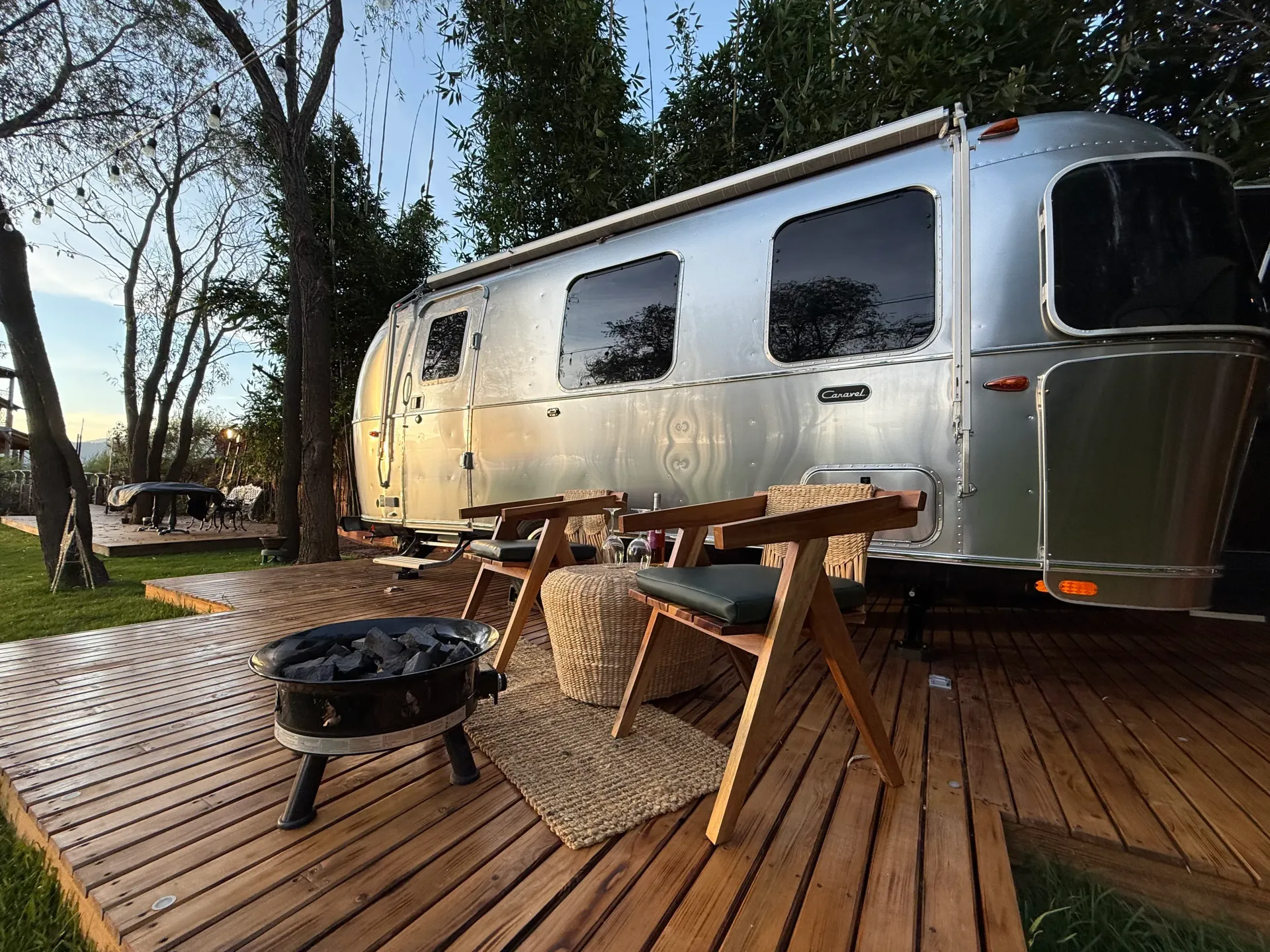 Un remolque Airstream plateado está estacionado en una plataforma de madera.