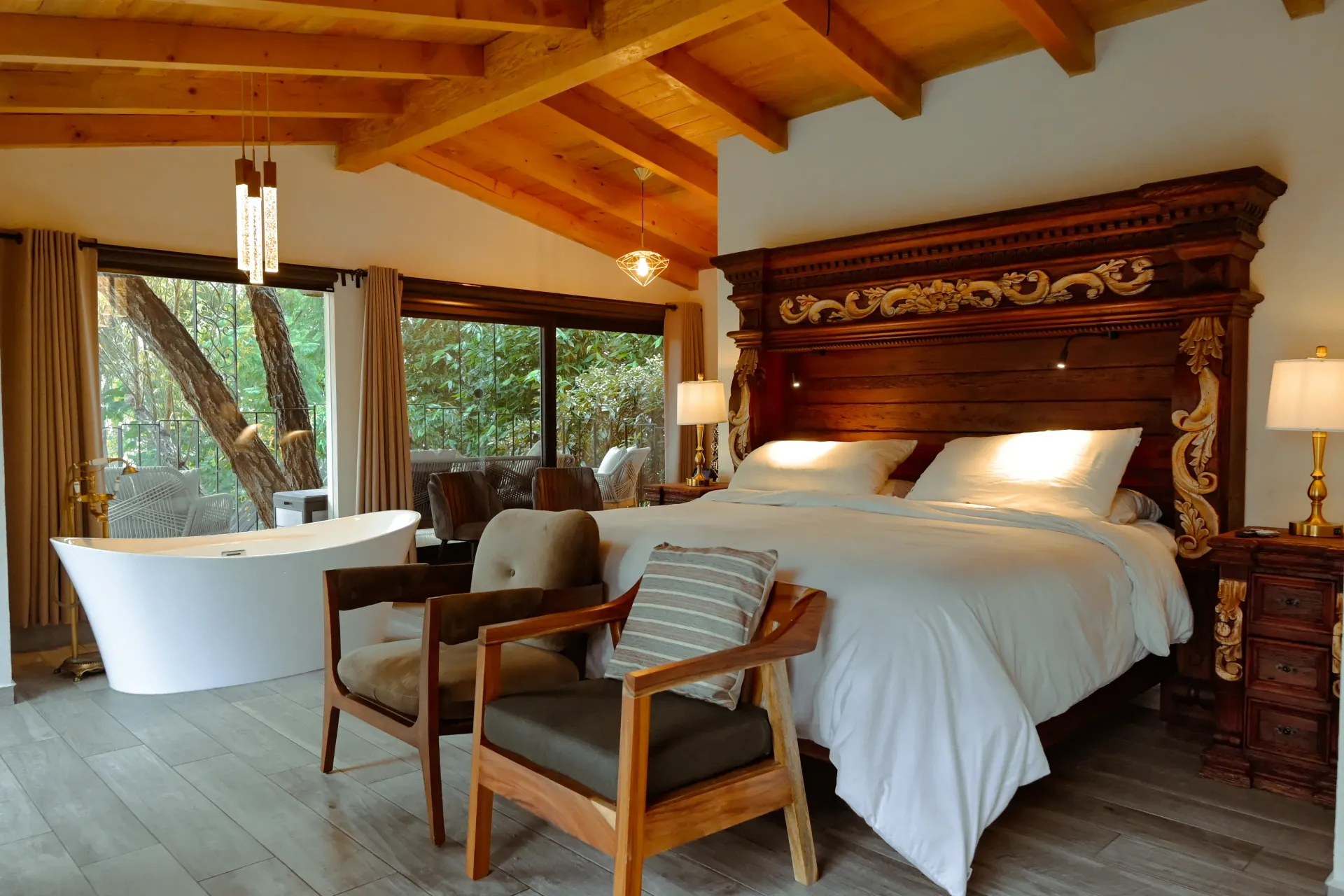 Un dormitorio con una cama grande, sillas y una bañera.
