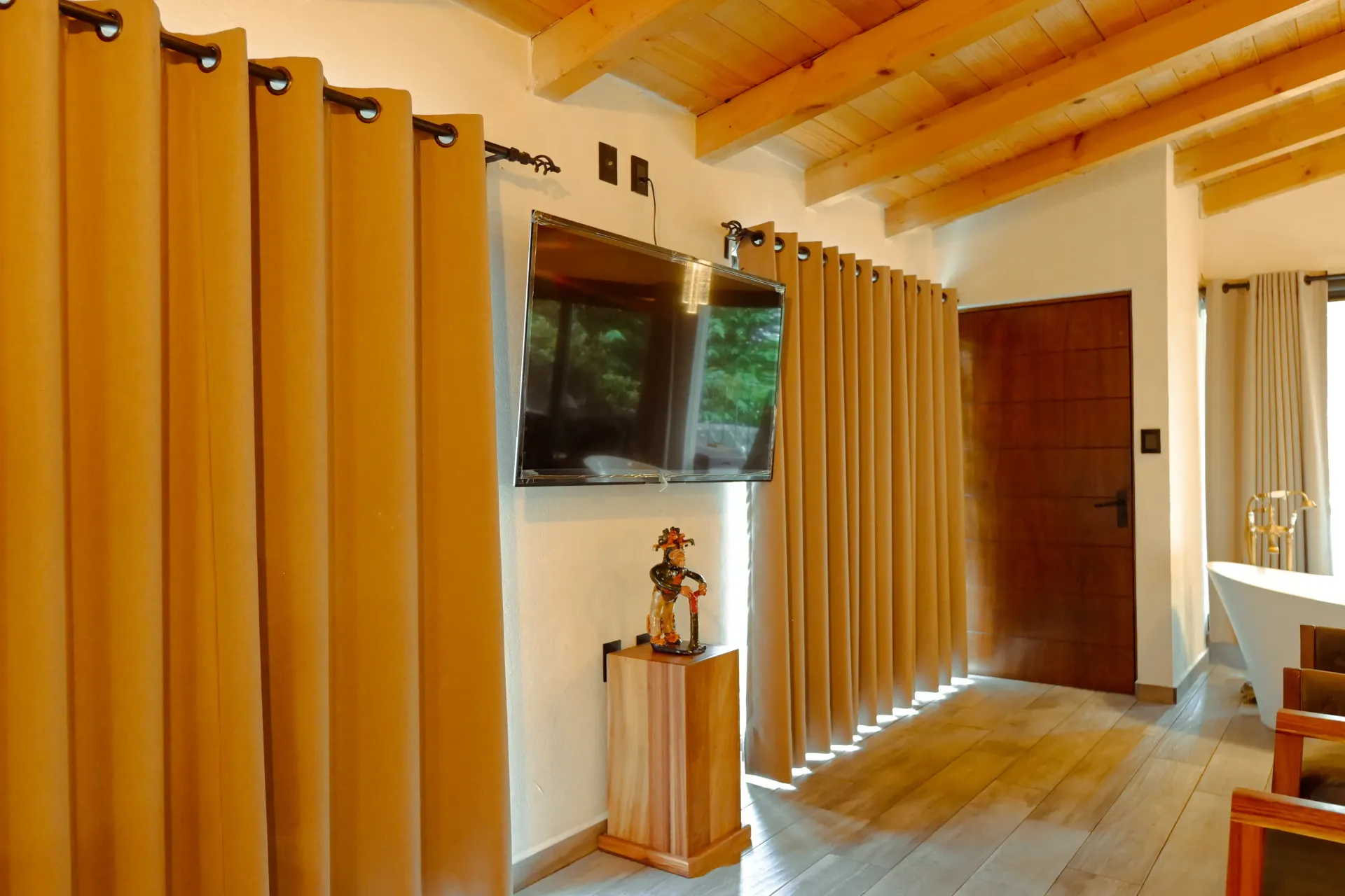 Una sala de estar con cortinas marrones y techo de madera.