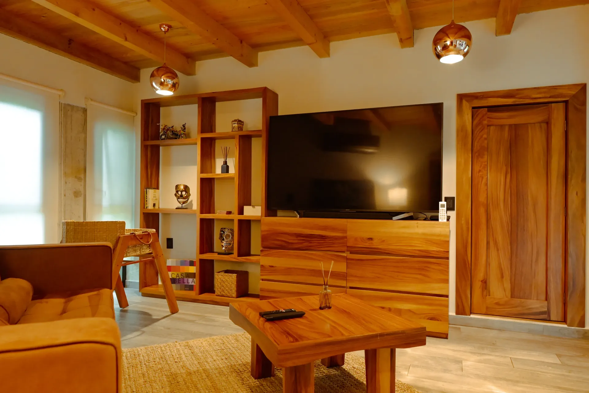 Una sala de estar con muebles de madera y TV de pantalla plana.