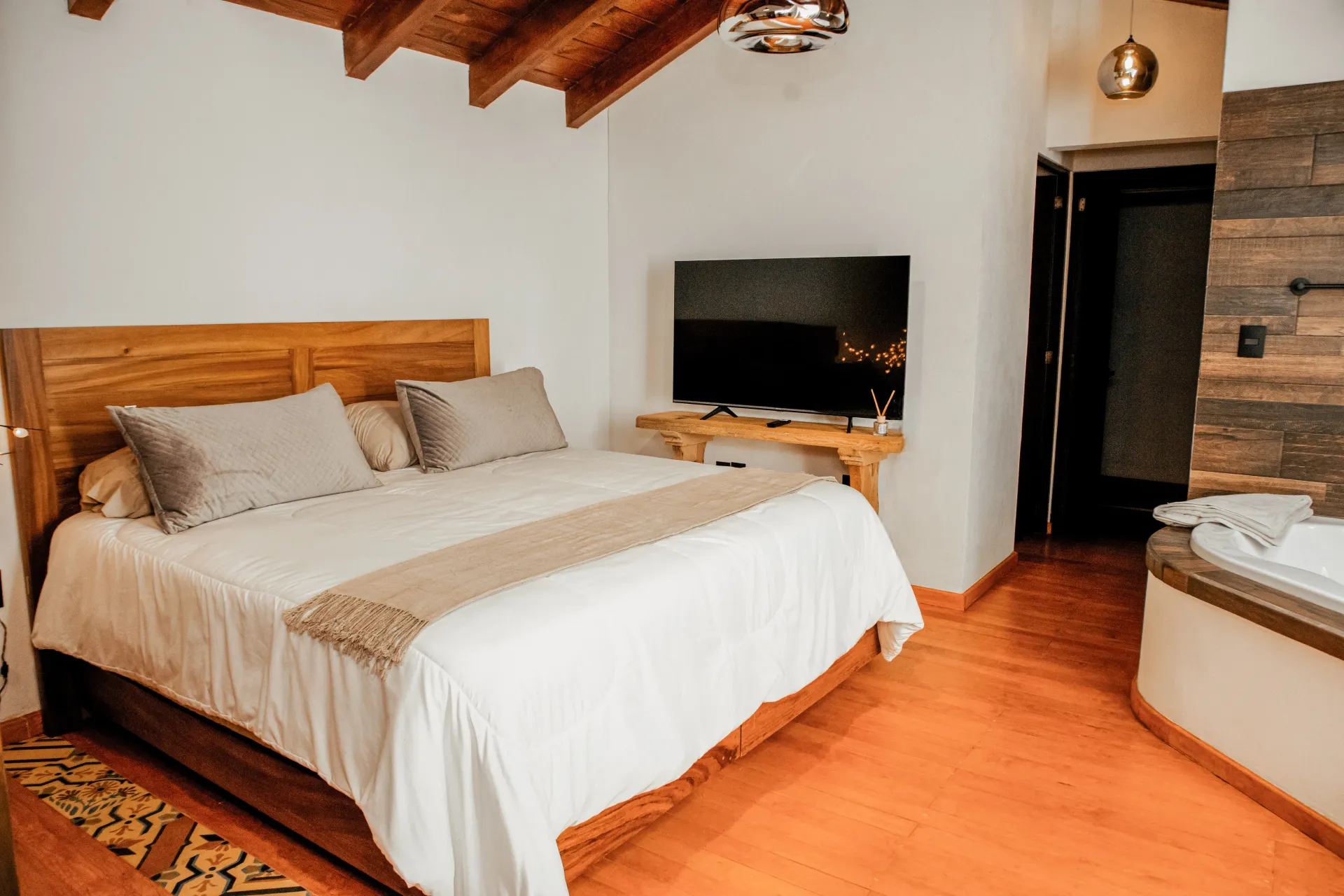 Un dormitorio con cama king size, televisión y bañera de hidromasaje.