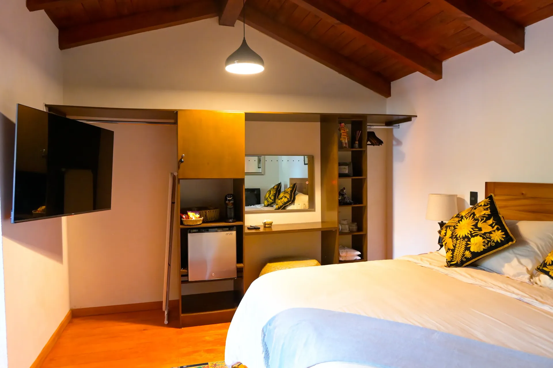 Una habitación de hotel con una cama grande y un televisor de pantalla plana.