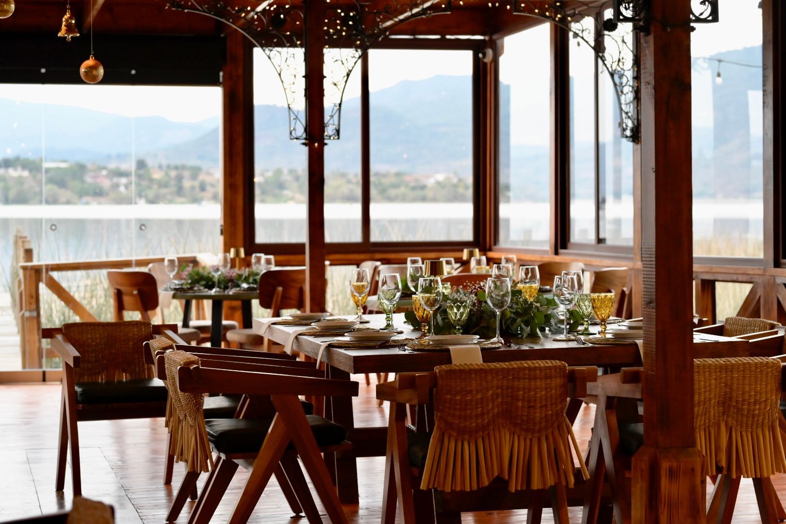 Un restaurante con mesas y sillas y vista a un lago.