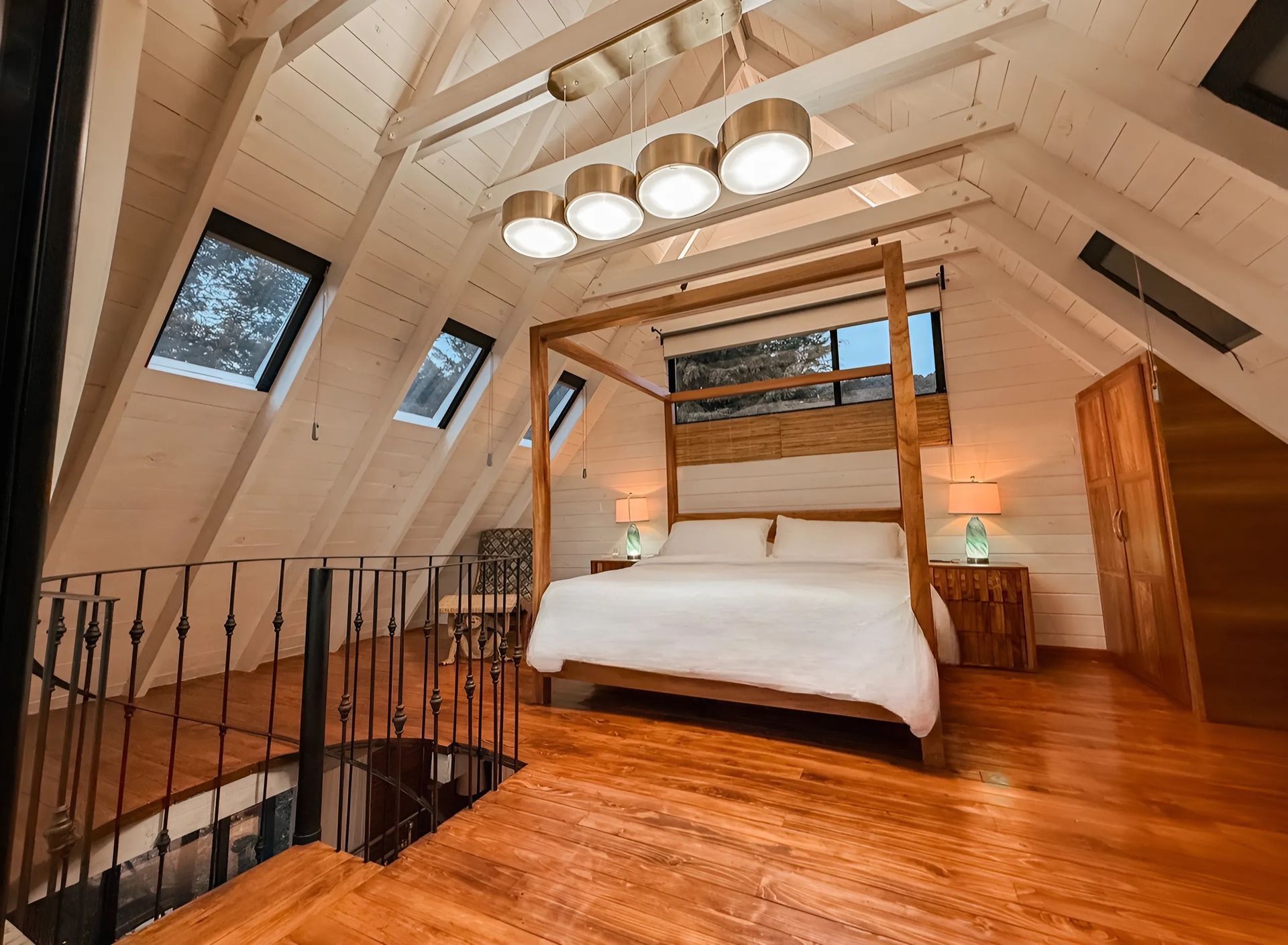 Un dormitorio con una cama con dosel y una escalera de caracol.