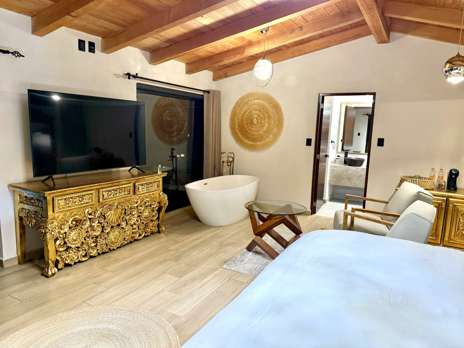 Un dormitorio con una cama grande, televisión y bañera.