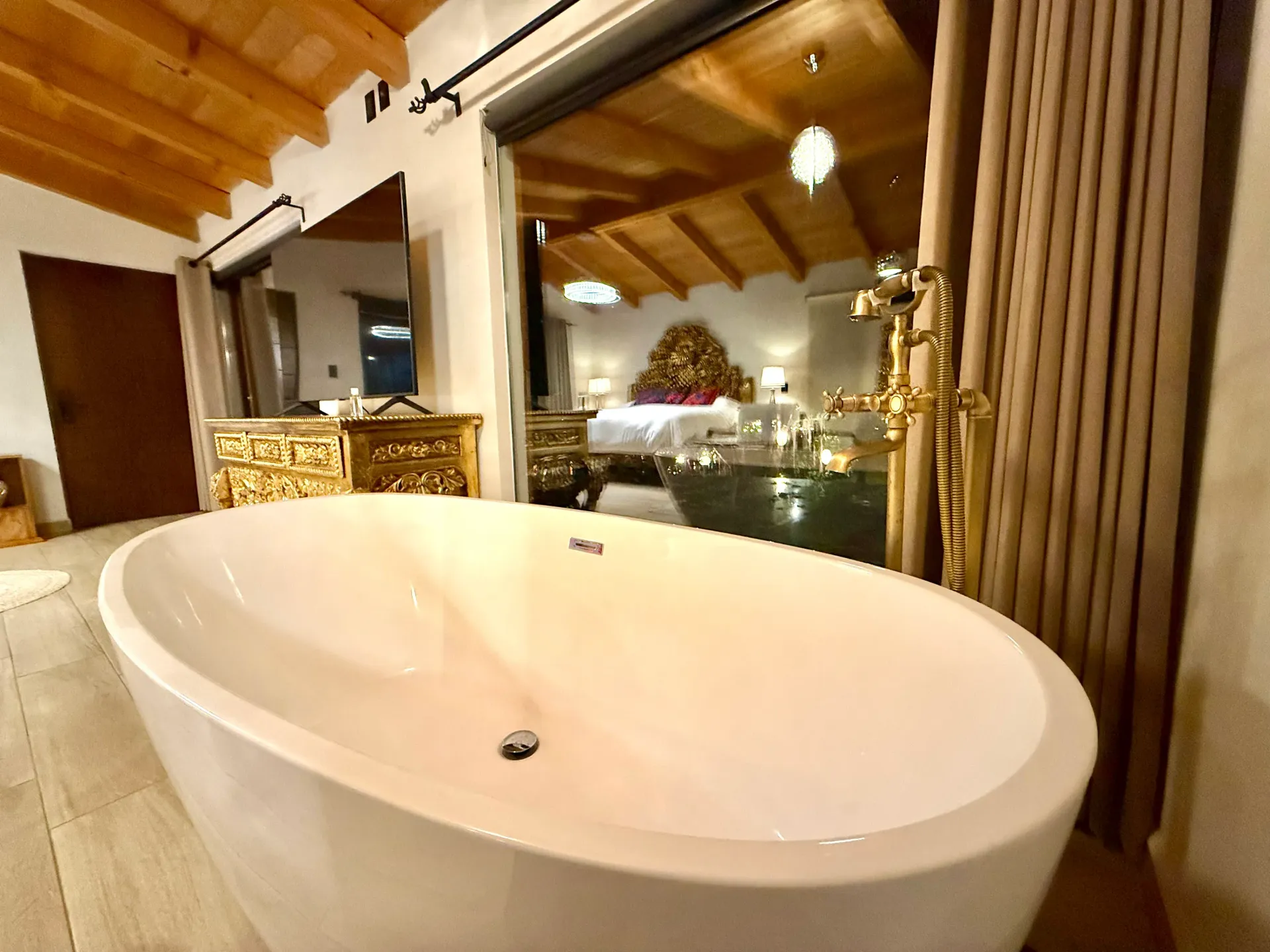 Una gran bañera blanca está en un baño al lado de una ventana.