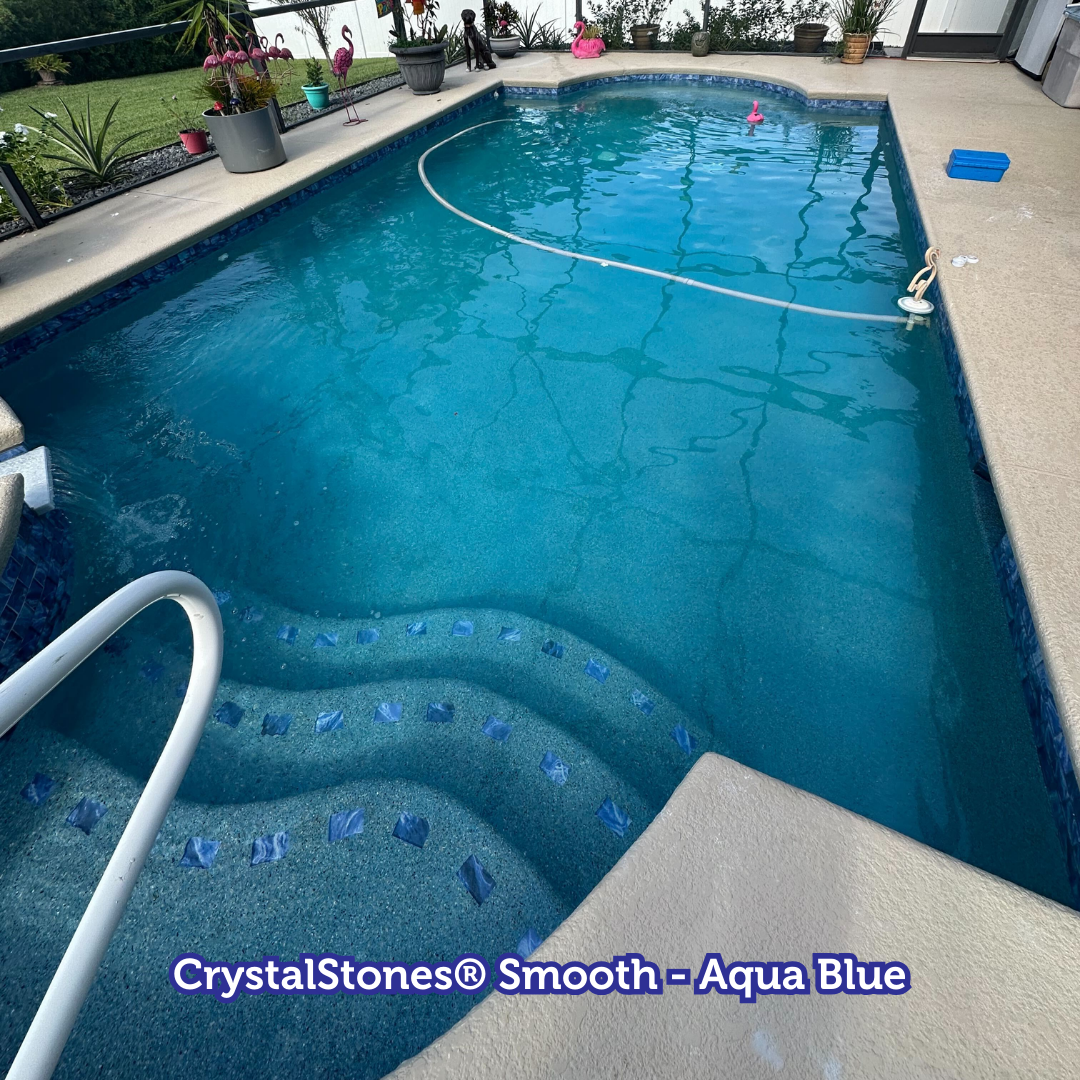 Pool with aqua blue finish, steps, and handrail, surrounded by concrete.