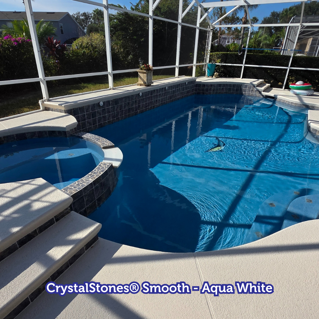 Pool with spa, blue water, light-colored deck, stone accents, screened enclosure, sunny day.