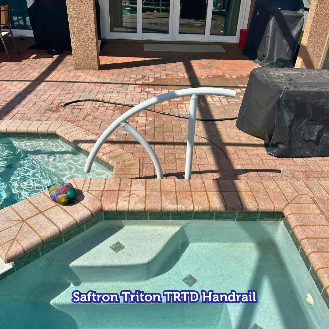 Pool with a Safron Triton TRTD handrail, brick patio, and steps.