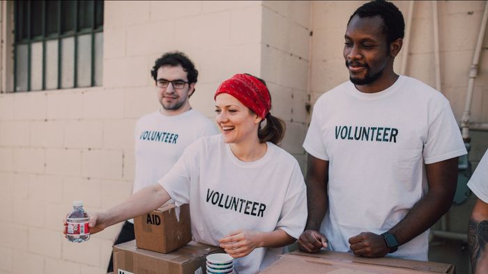 A group of volunteers are standing around a table.