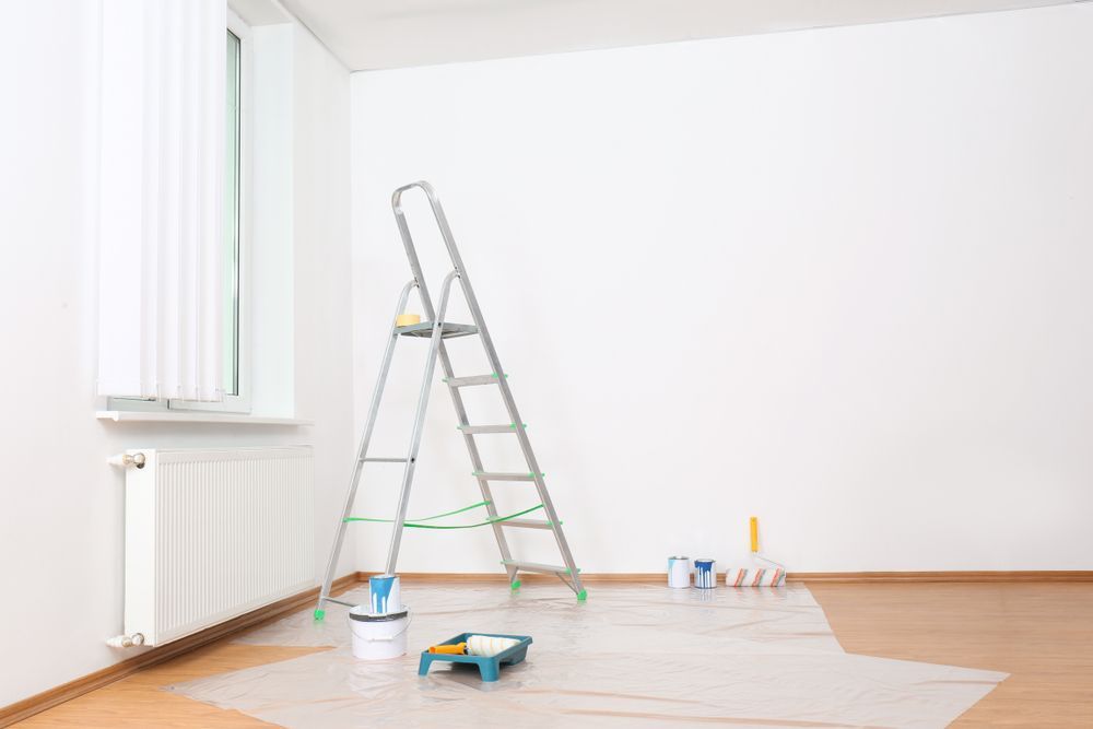 An Empty Room With A Ladder, Paint, And Rollers — Aaron Lee Painting Pty Ltd In Jensen, QLD