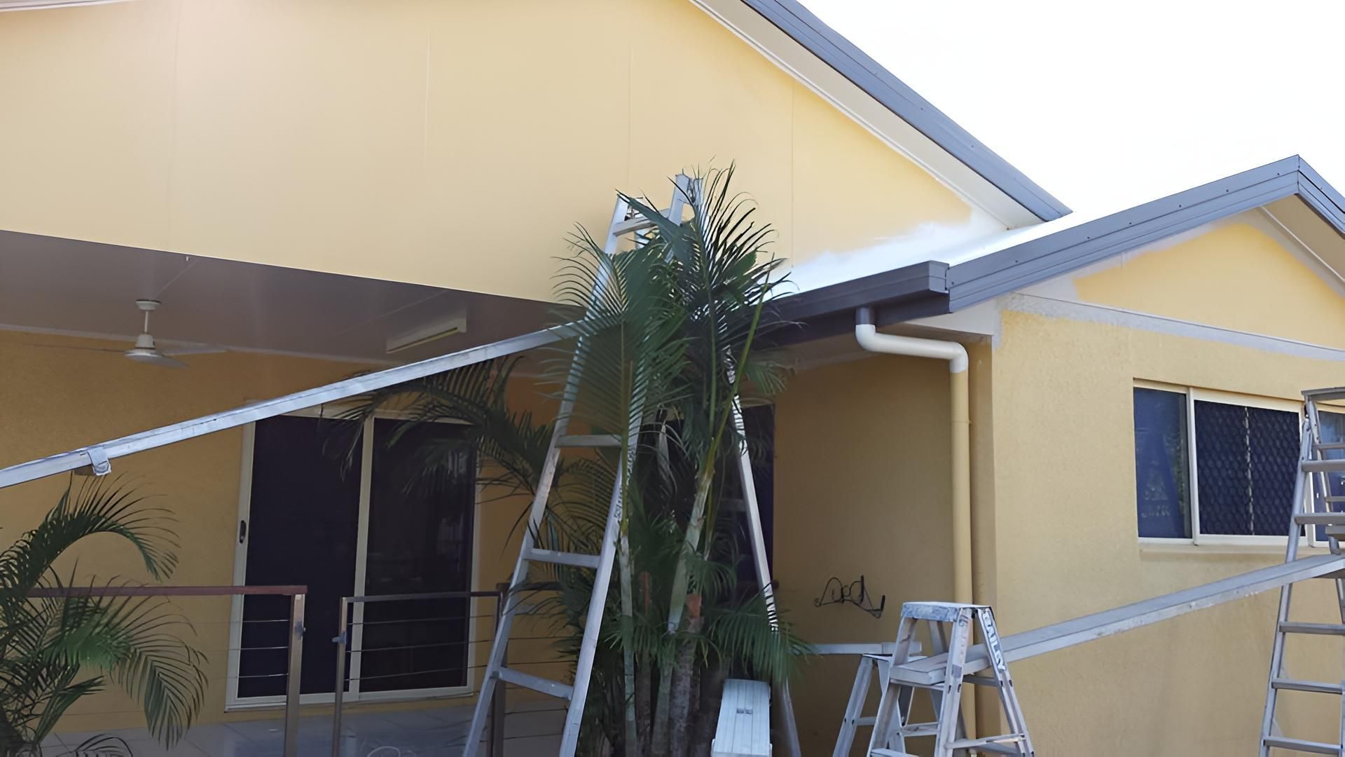 A Yellow House With A Ladder In Front Of It — Aaron Lee Painting Pty Ltd In Townsville, QLD