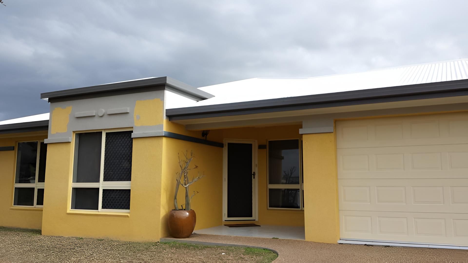 A Yellow House With A White Garage Door — Aaron Lee Painting Pty Ltd In Belgian Gardens, QLD