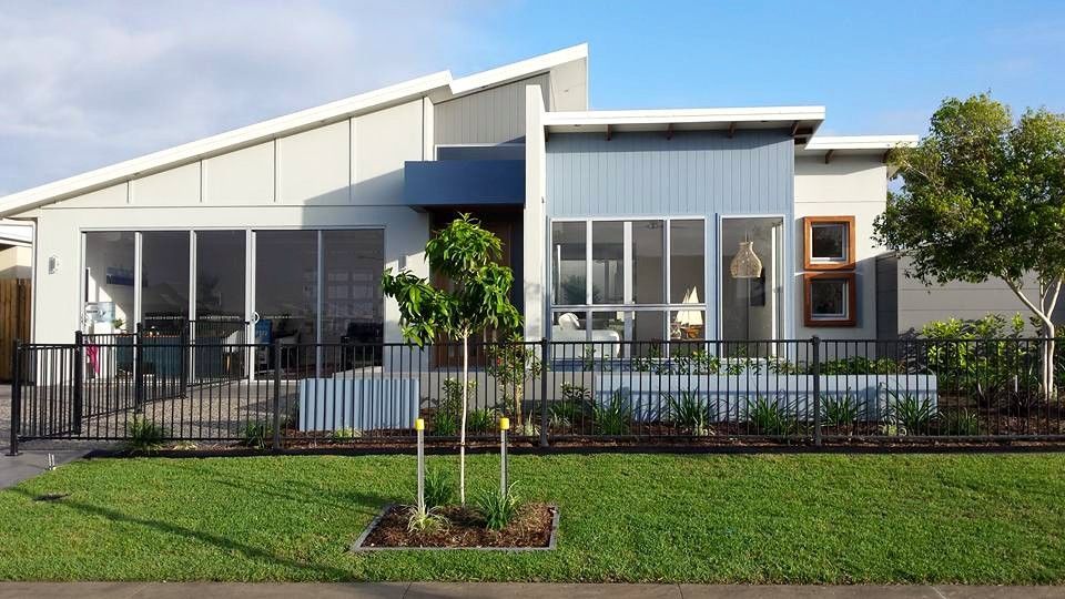 A Modern House With A Lot Of Windows And A Fence In Front Of It — Aaron Lee Painting Pty Ltd In Bushland Beach, QLD