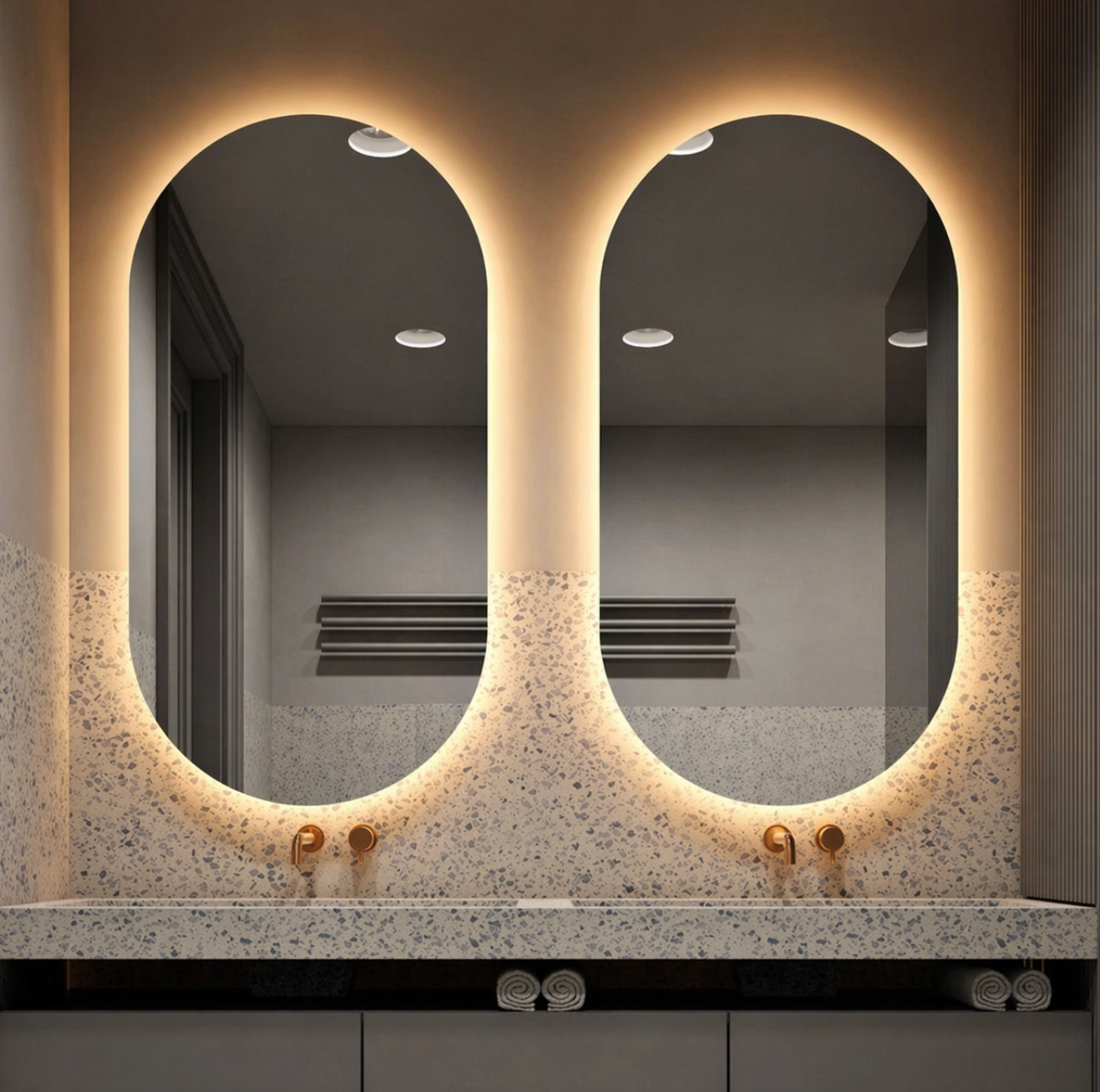 Modern bathroom vanity with two backlit oval mirrors and speckled stone countertop