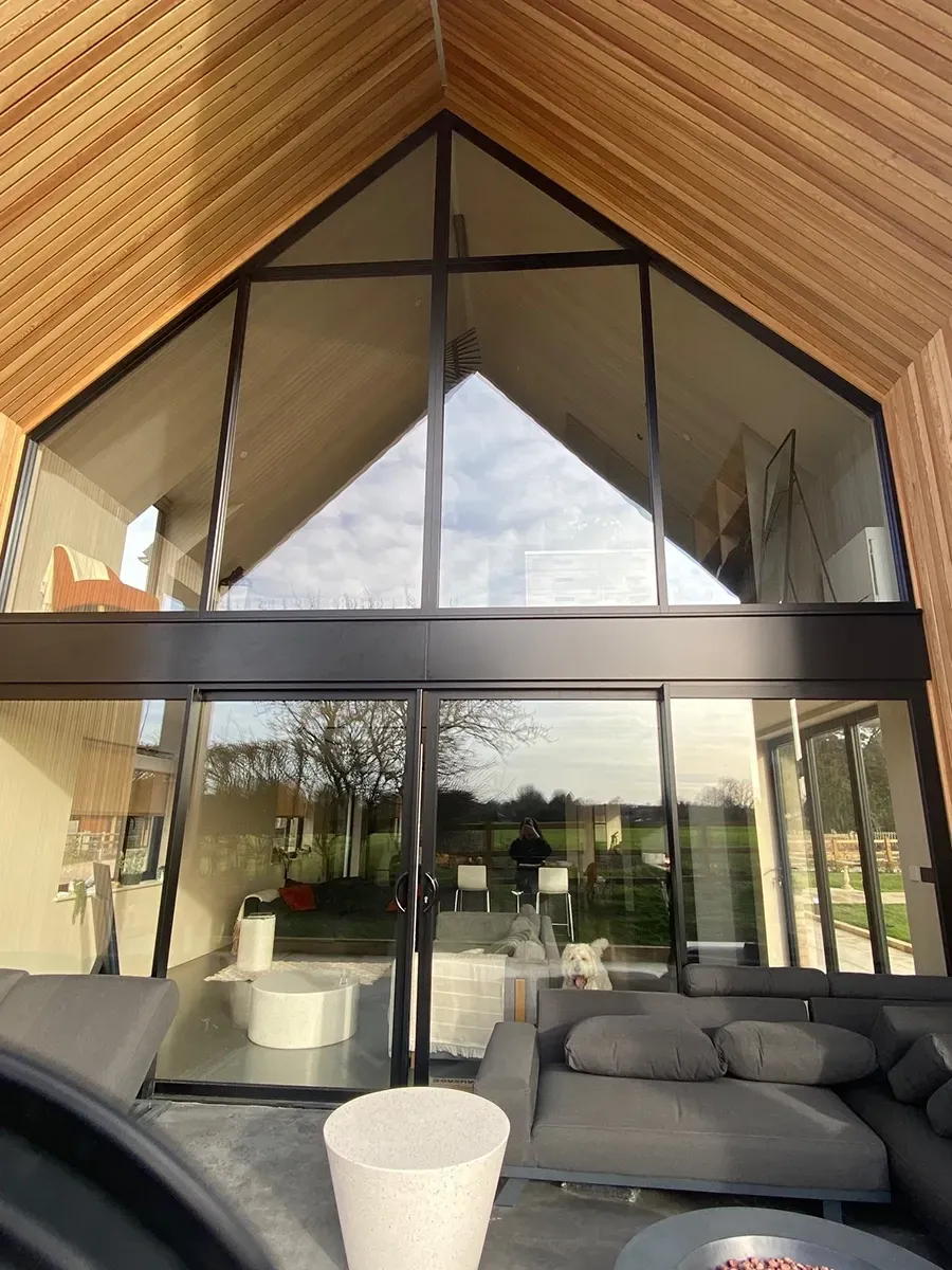 A living room with a vaulted ceiling and lots of windows