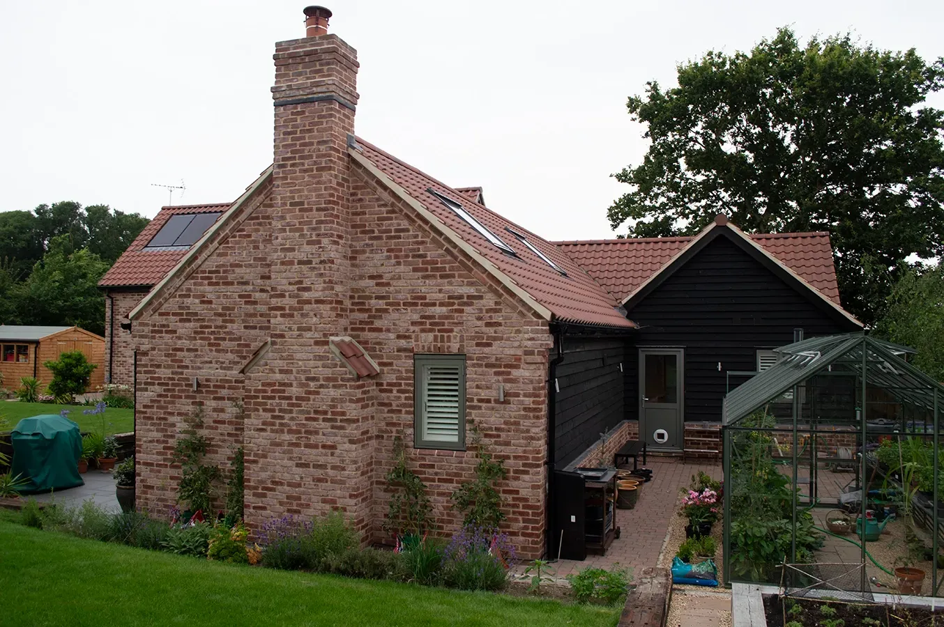 A brick house with a black roof and a chimney