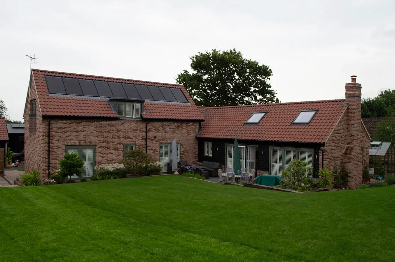 A large brick house with a lush green lawn in front of it