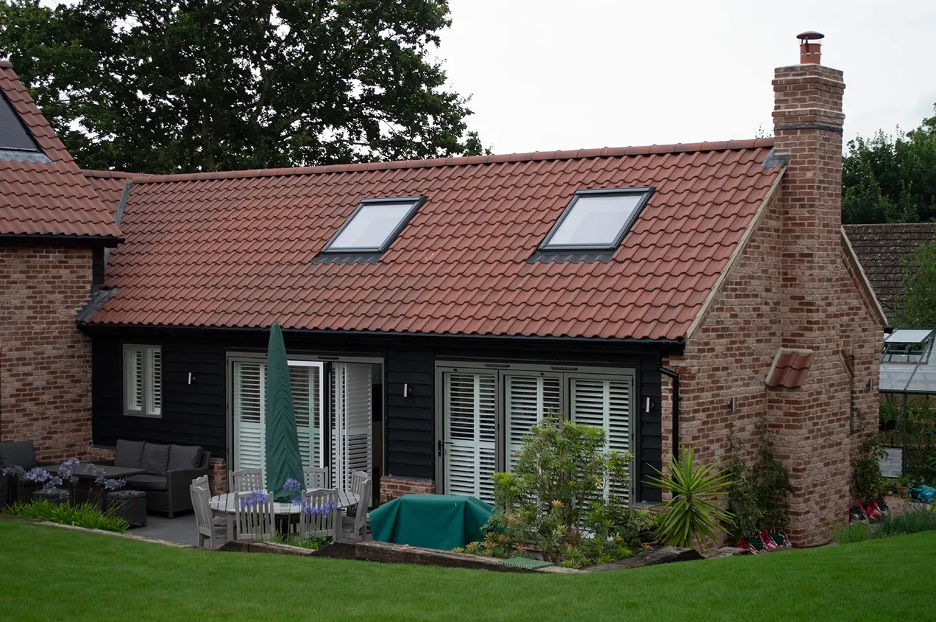 A house with a red tiled roof and two skylights