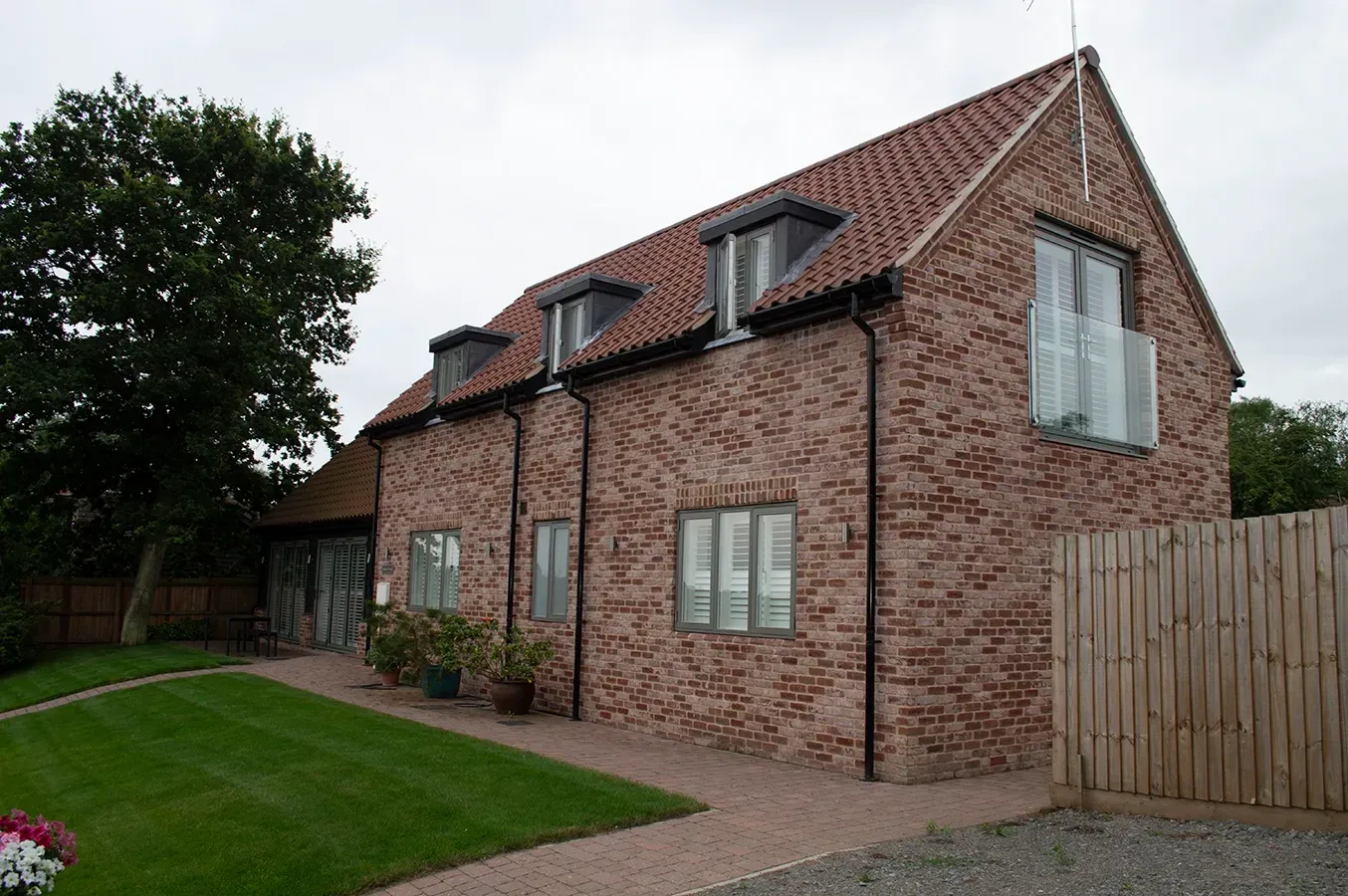 A large brick house with a wooden fence in front of it