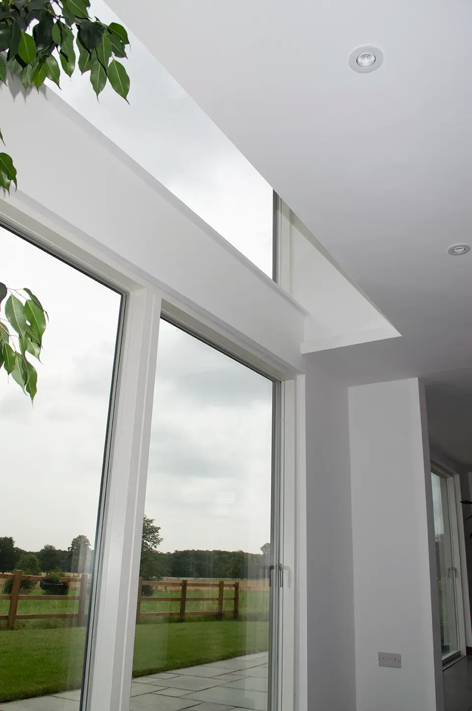A large window in a room with a view of a field