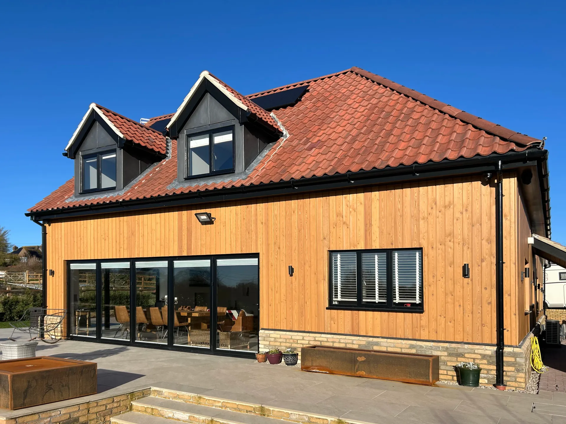 A large house with a red tile roof and wooden siding