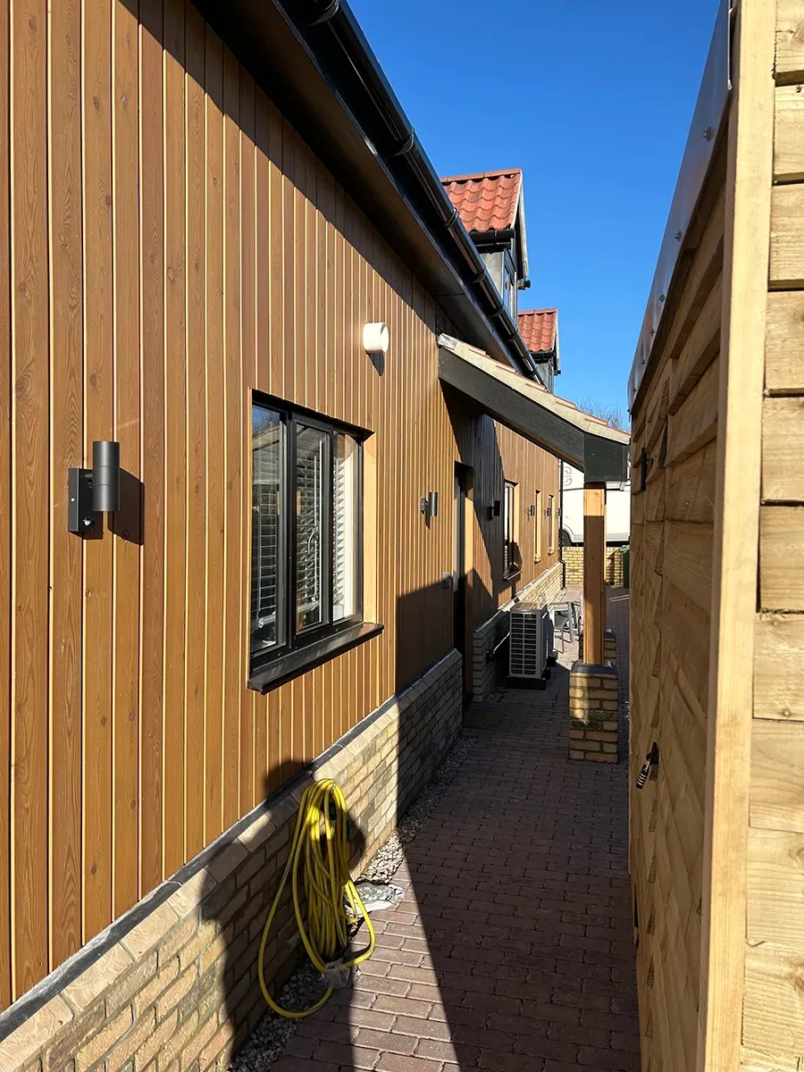 A wooden building with a hose on the side of it