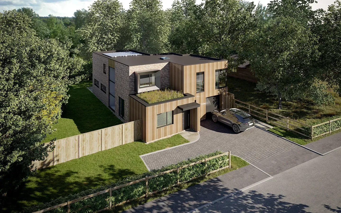 An aerial view of a house with a car parked in front of it surrounded by trees.