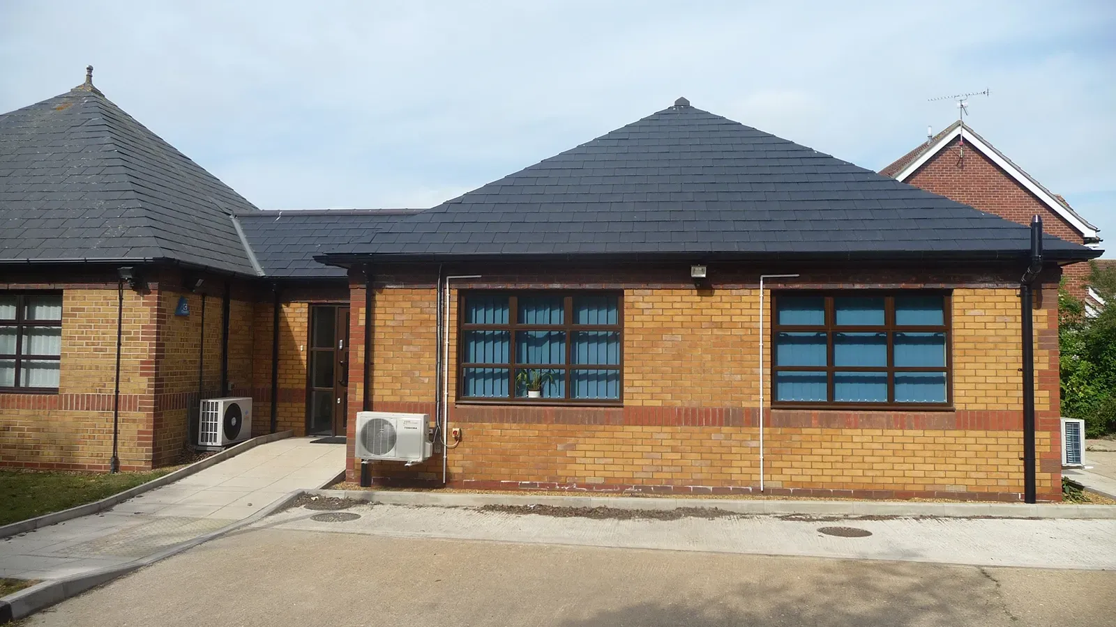 A small brick building with a black roof