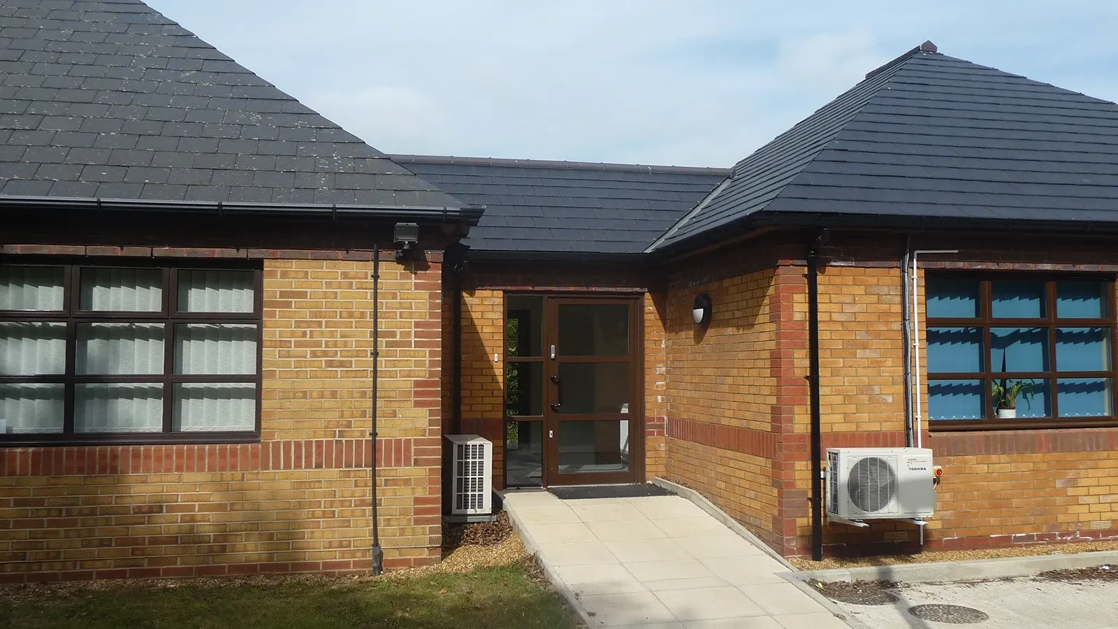 A brick building with a black roof and a black door