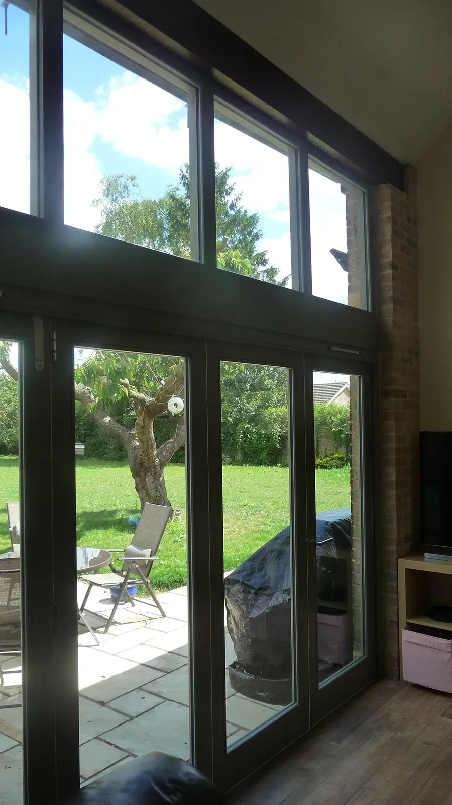 A living room with a lot of windows and a view of a yard.