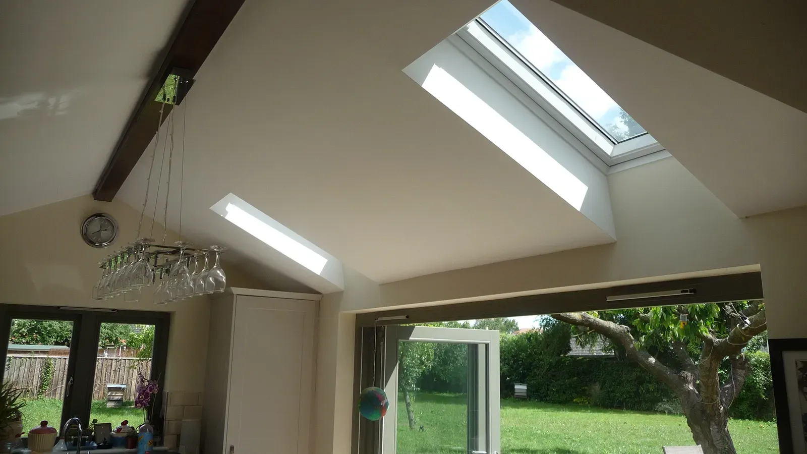 A kitchen with a skylight and a sliding glass door.
