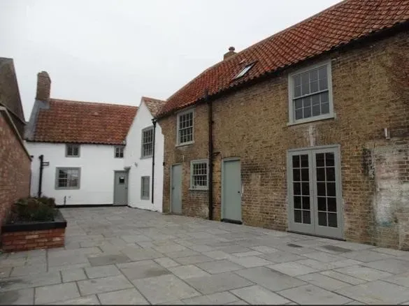 A brick building with a white building in the background