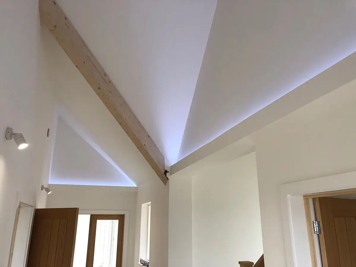 A hallway with a vaulted ceiling and wooden beams.