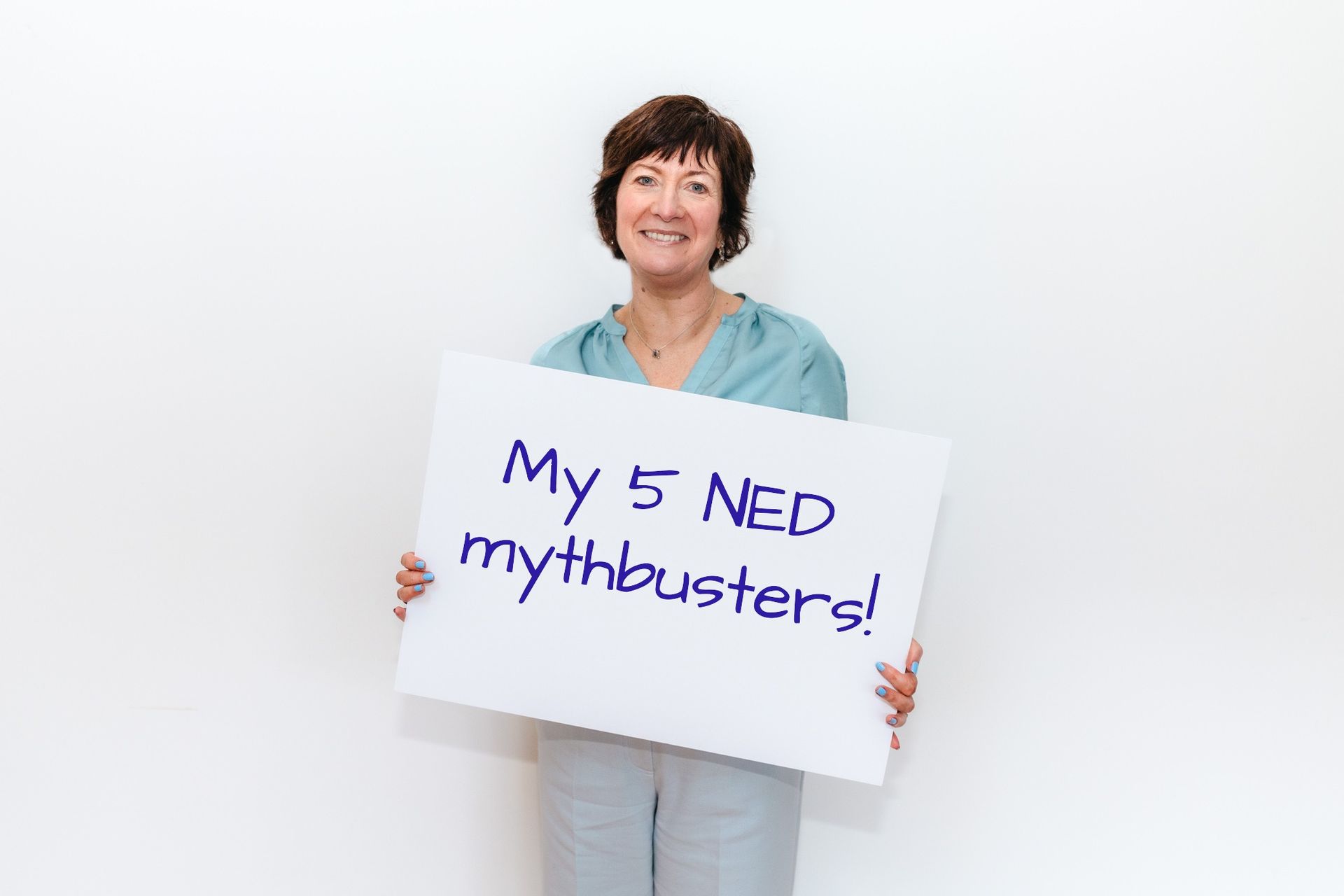 Female Executive coach holding placarding saying My 5 NED mythbusters